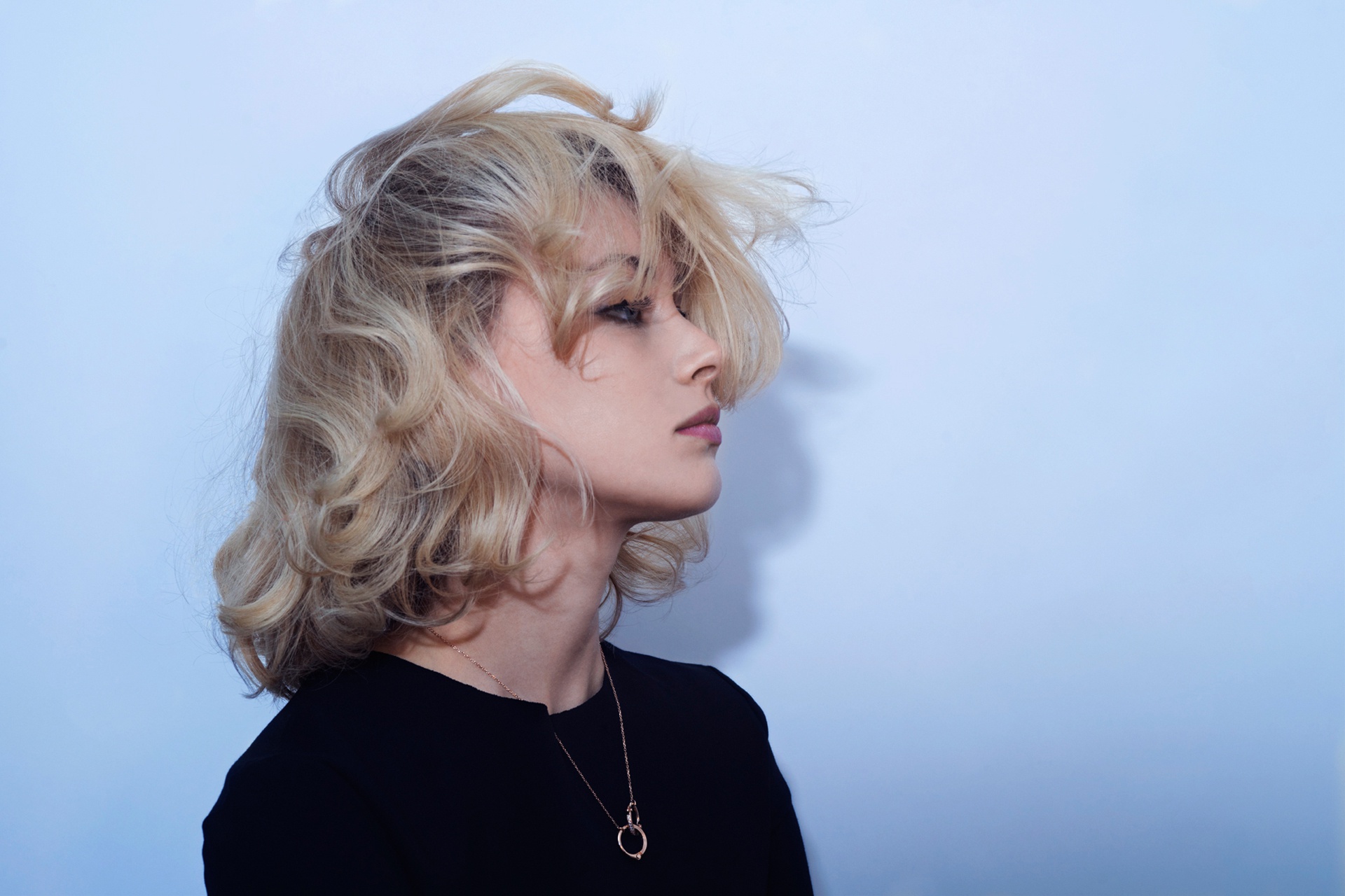 People 1920x1280 women model simple background blue background necklace black clothing looking away hair in face short hair blonde dyed hair lipstick