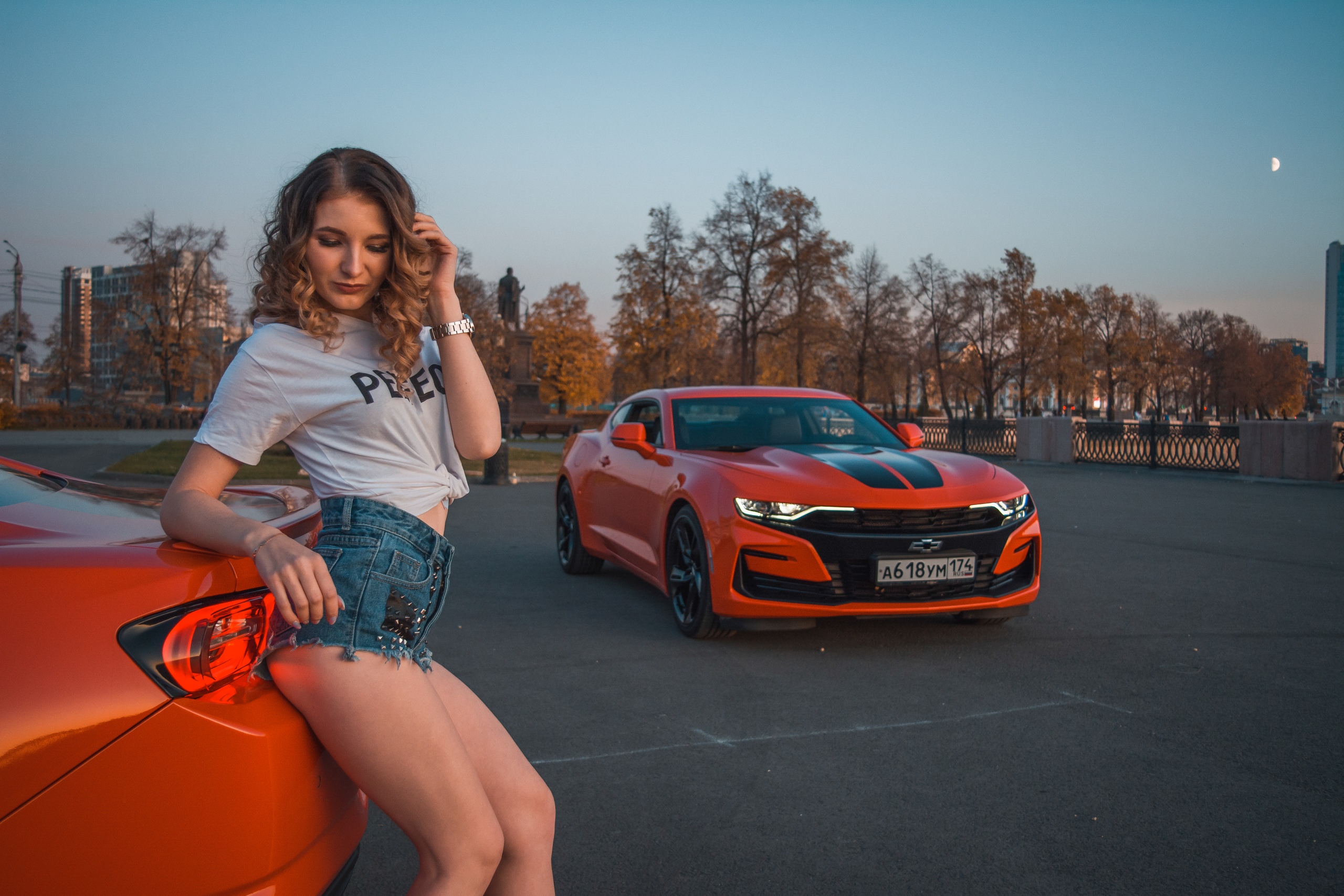 People 2560x1707 women women with cars curly hair trees sky women outdoors building white t-shirt watch Moon Chevrolet red cars car vehicle Chevrolet Camaro muscle cars American women