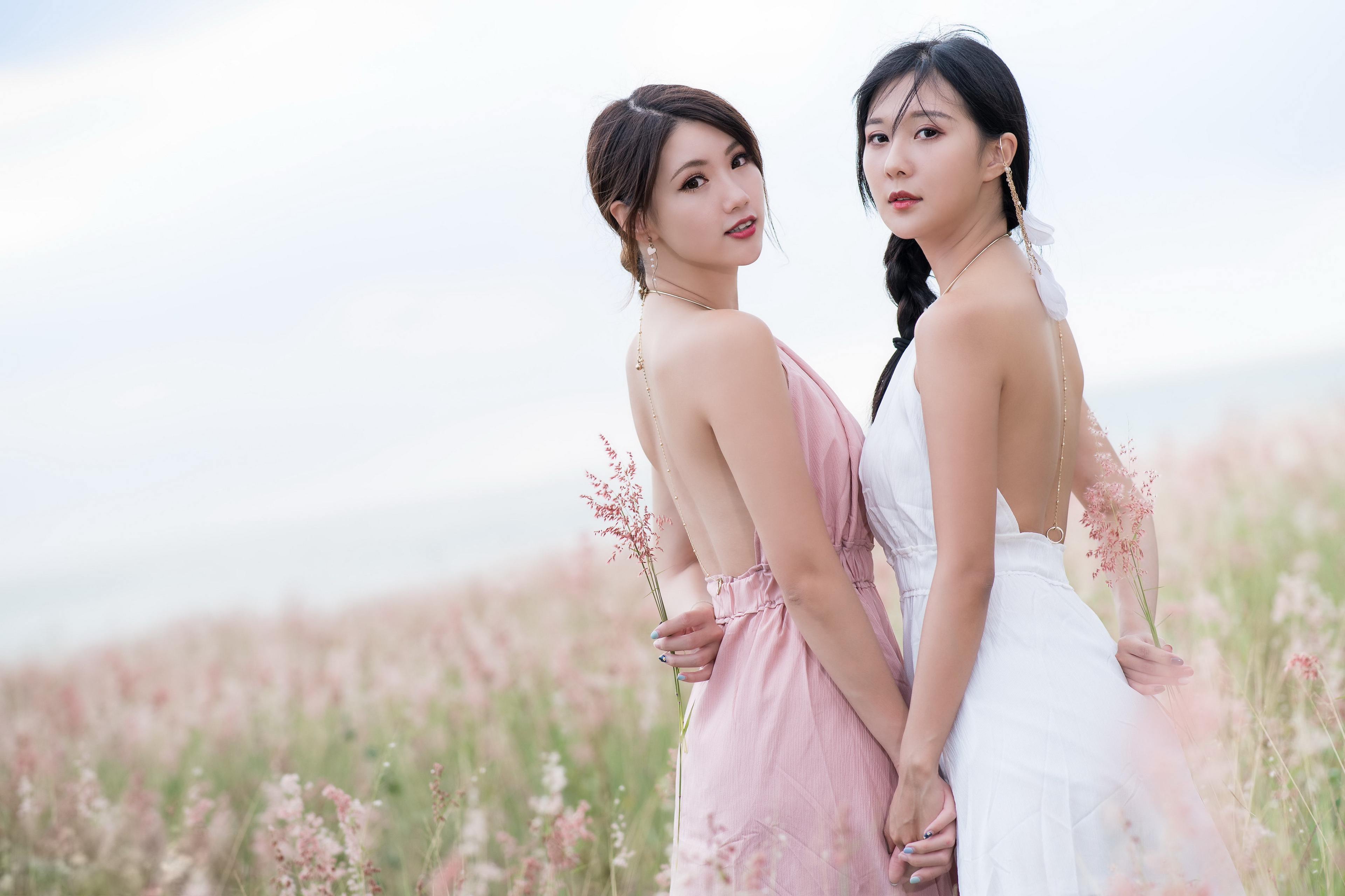 People 3840x2559 Asian model women long hair brunette pink dress white dress braids ponytail holding hands earring looking at viewer two women field flowers