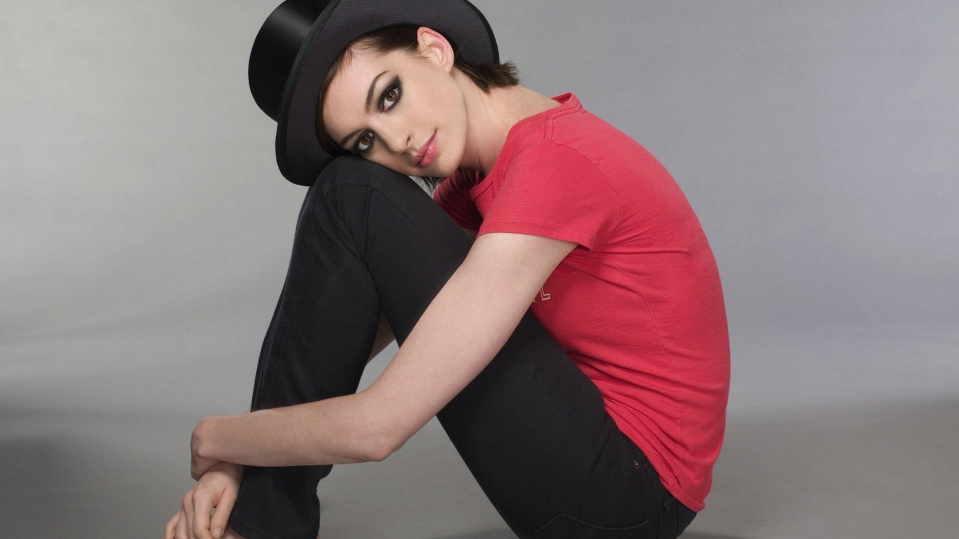 People 3840x2160 women dark hair Anne Hathaway red t-shirt actress hat women with hats makeup sitting women indoors looking at viewer simple background gray background studio