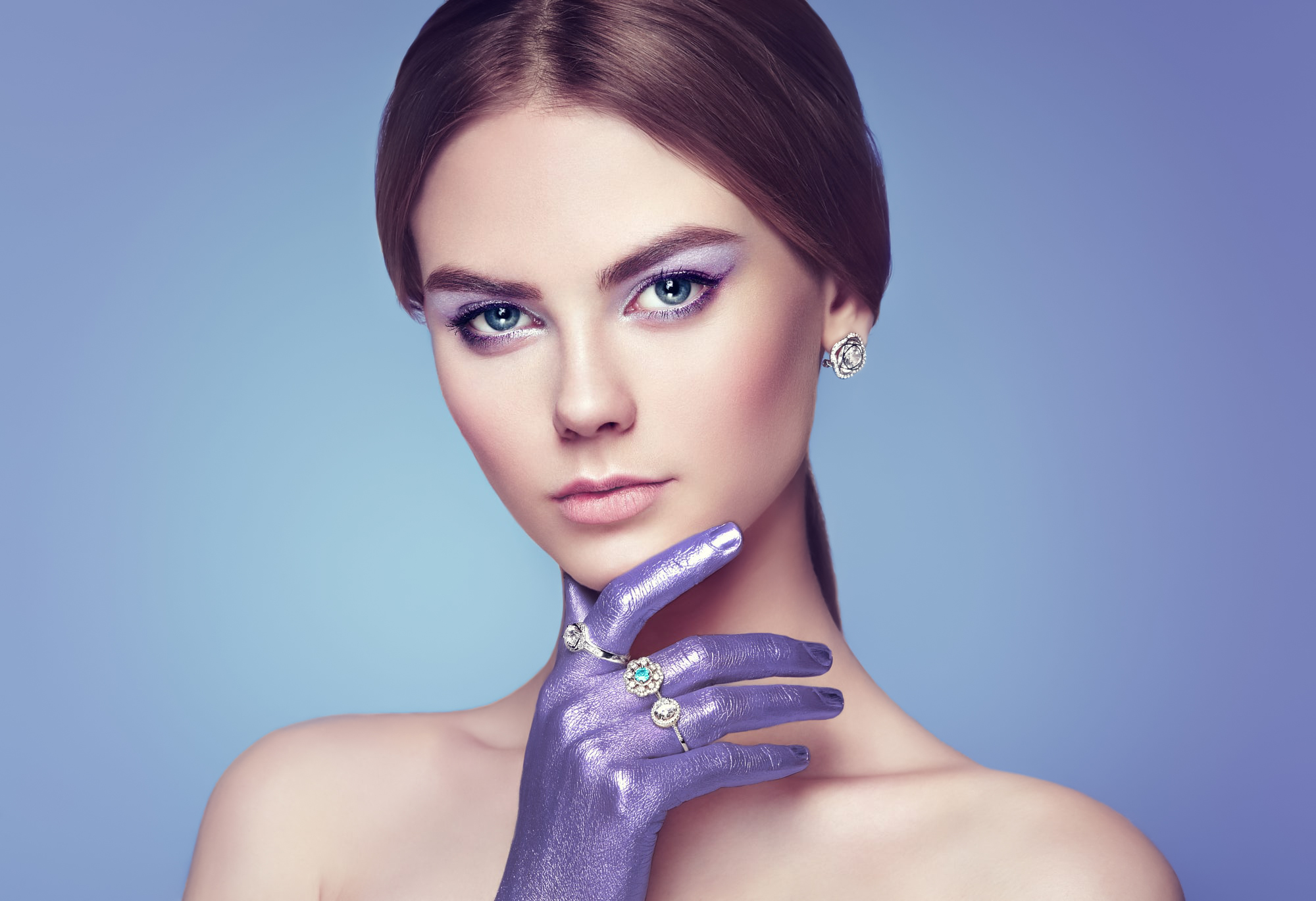 People 2000x1369 Oleg Gekman women Anna Nosova brunette makeup eyeshadow looking at viewer body paint glamour blue eyes jewelry earring rings silver blushing eyeliner lipstick simple background blue background bare shoulders face