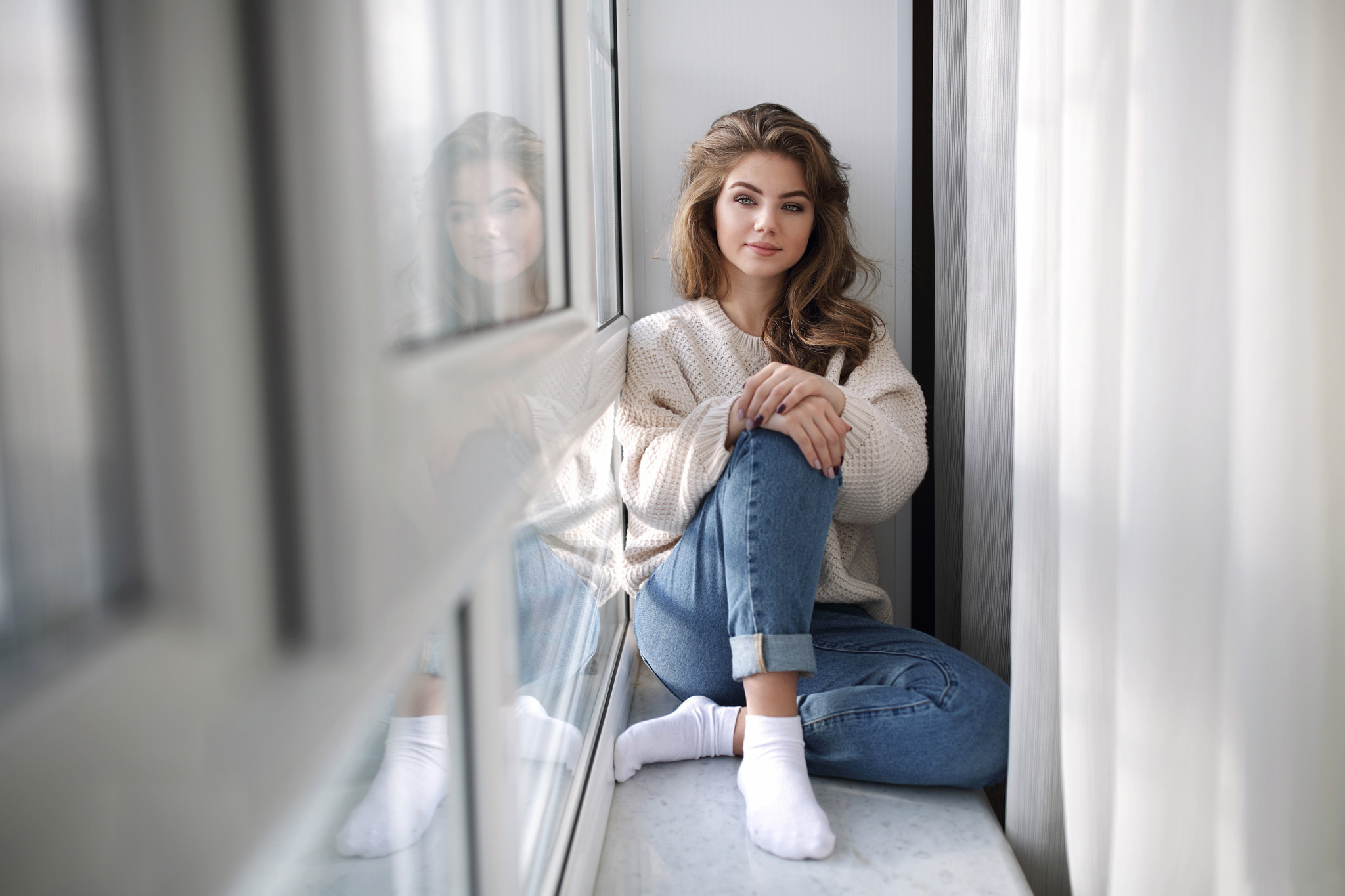 People 2048x1365 women sitting jeans window smiling reflection portrait socks white sweater white socks Margarita Murat window sill short socks looking at viewer hands on knees feet crossed pointed toes sweater model blue pants tight pants blue  jeans
