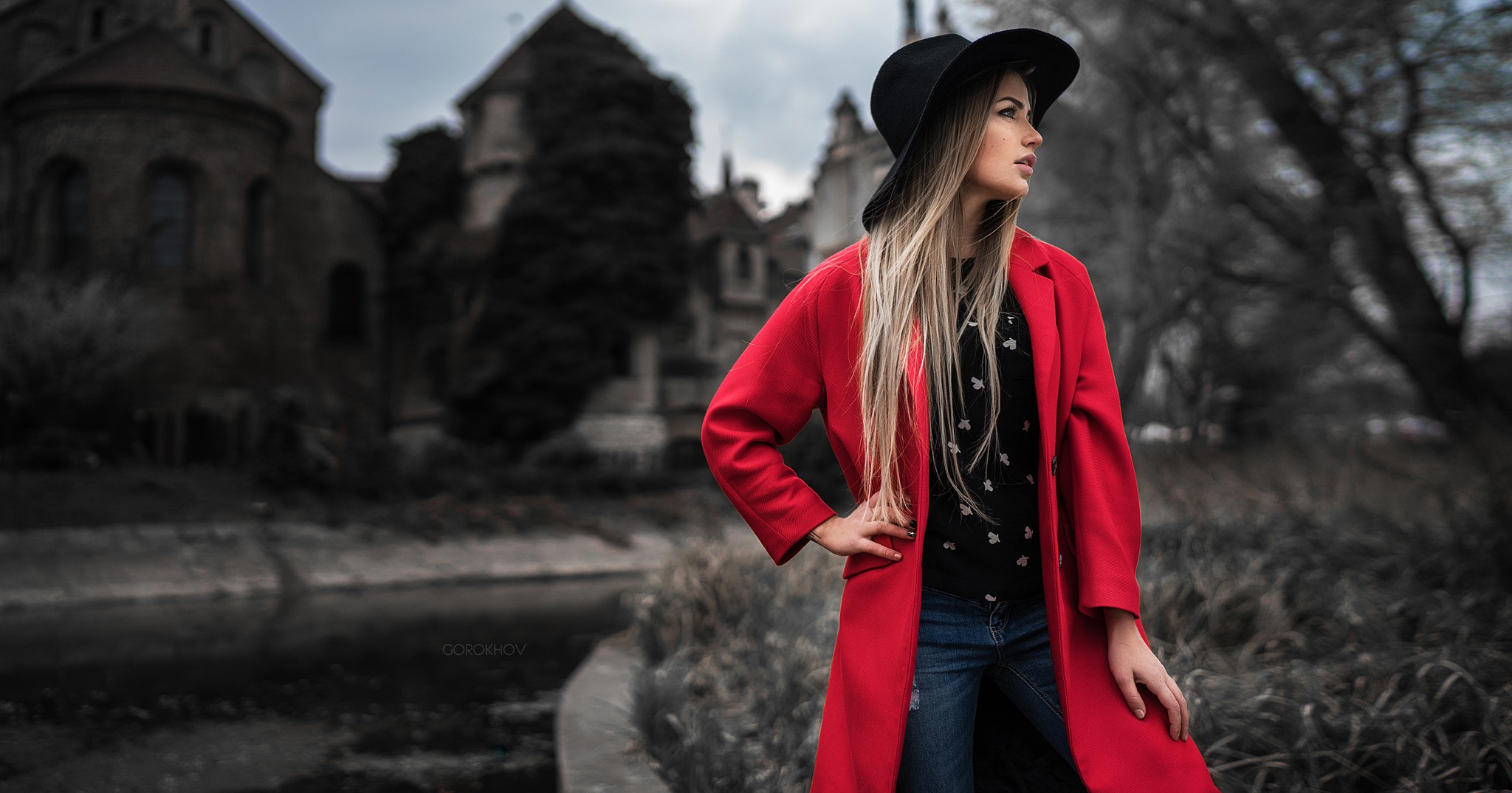 People 2048x1074 women blonde hat looking away pants jeans Ivan Gorokhov standing long hair straight hair millinery Maria Puchnina red coat looking into the distance women outdoors open coat hands on hips black hat women with hats blue pants coats painted nails blue  jeans model