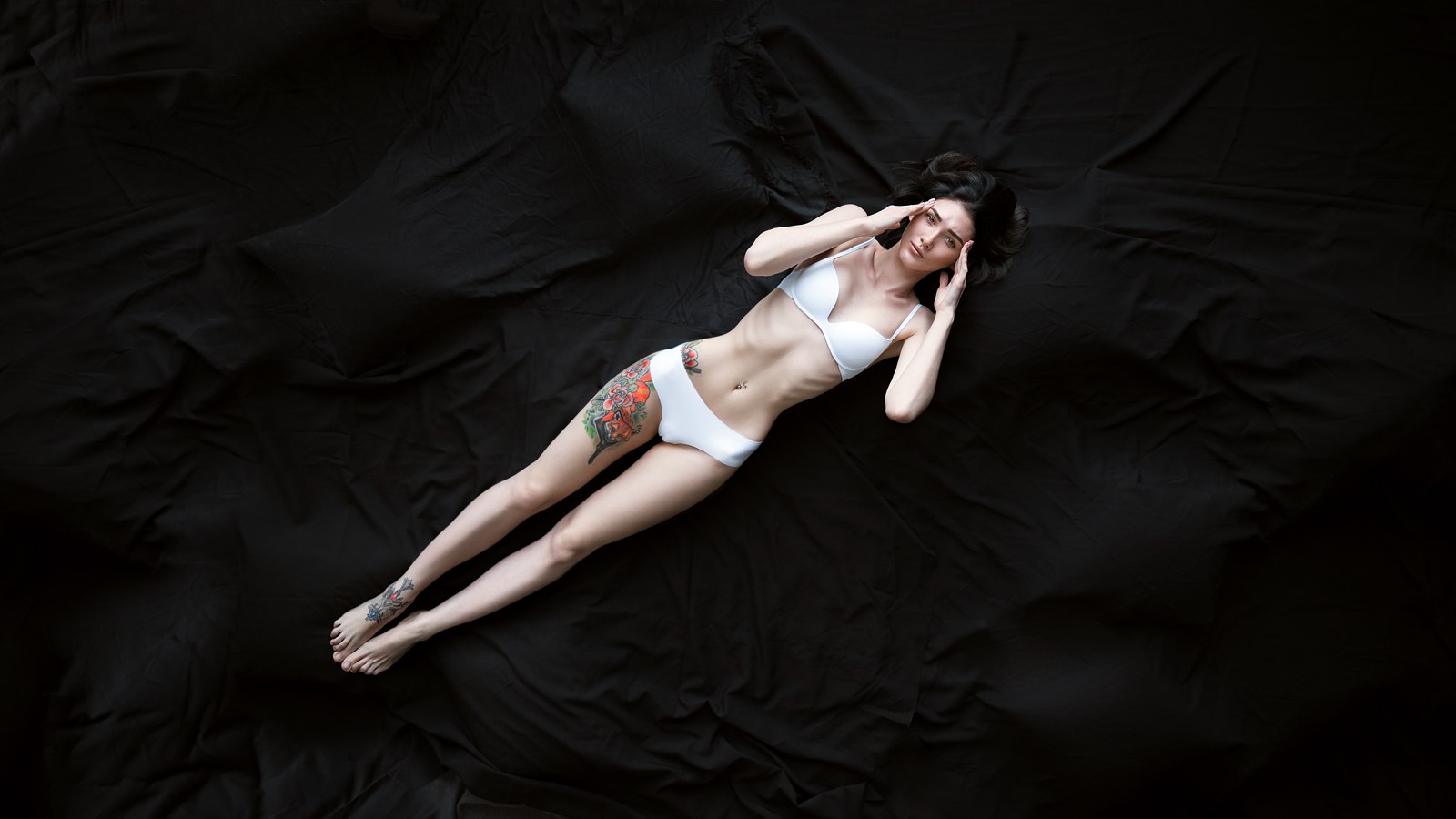 People 1600x900 women brunette top view lying on back underwear skinny white panties white bra pierced navel tattoo ribs simple background Maxim Gustarev barefoot white lingerie frontal view folded hands whole body black background the gap pale looking at viewer dark background belly hands on head