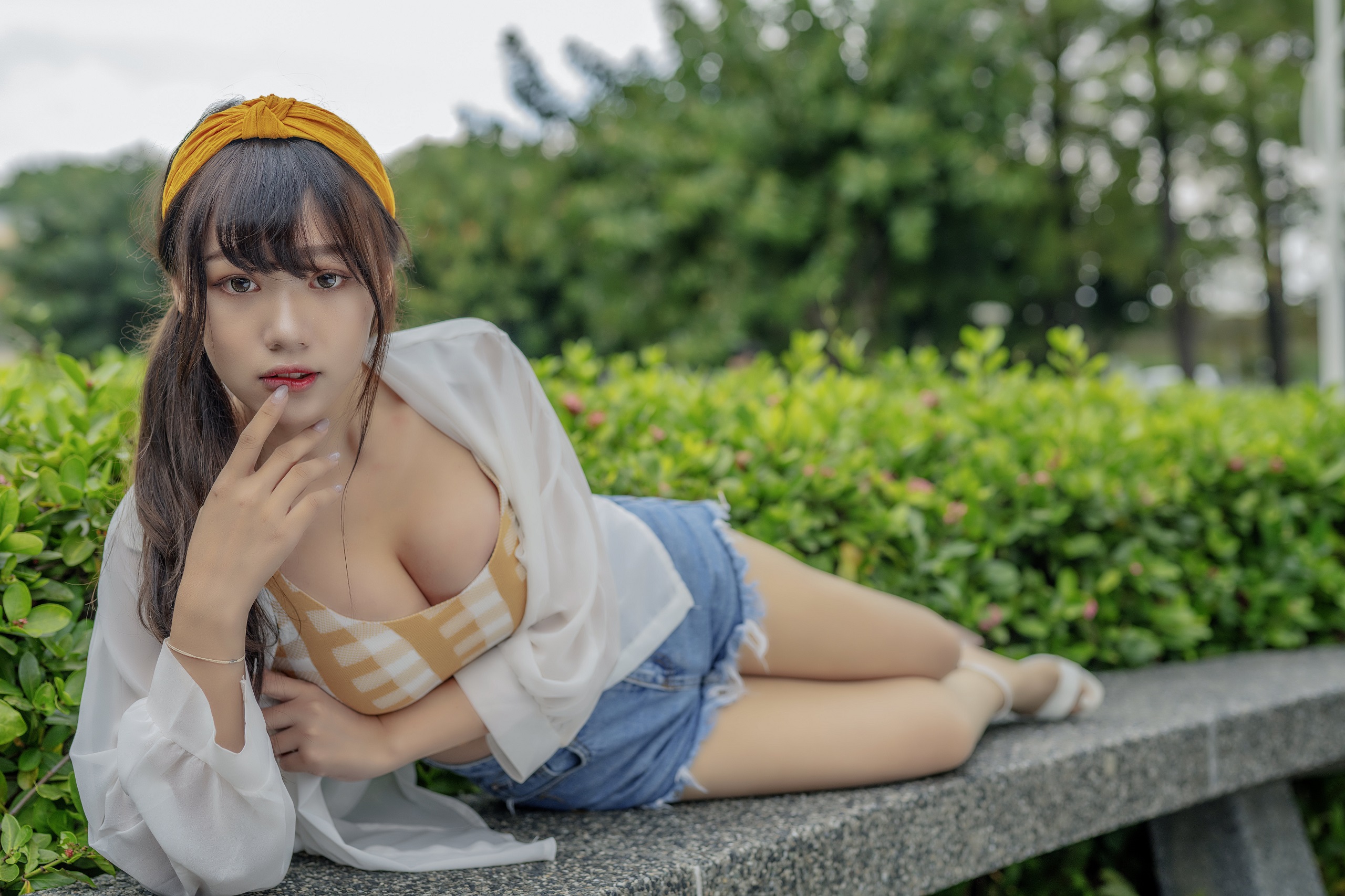 People 2560x1707 Asian women model portrait brunette long hair looking at viewer ponytail headband cleavage finger on lips crop top shirt white shirt jean shorts lying on side bokeh bushes outdoors women outdoors Linnnng