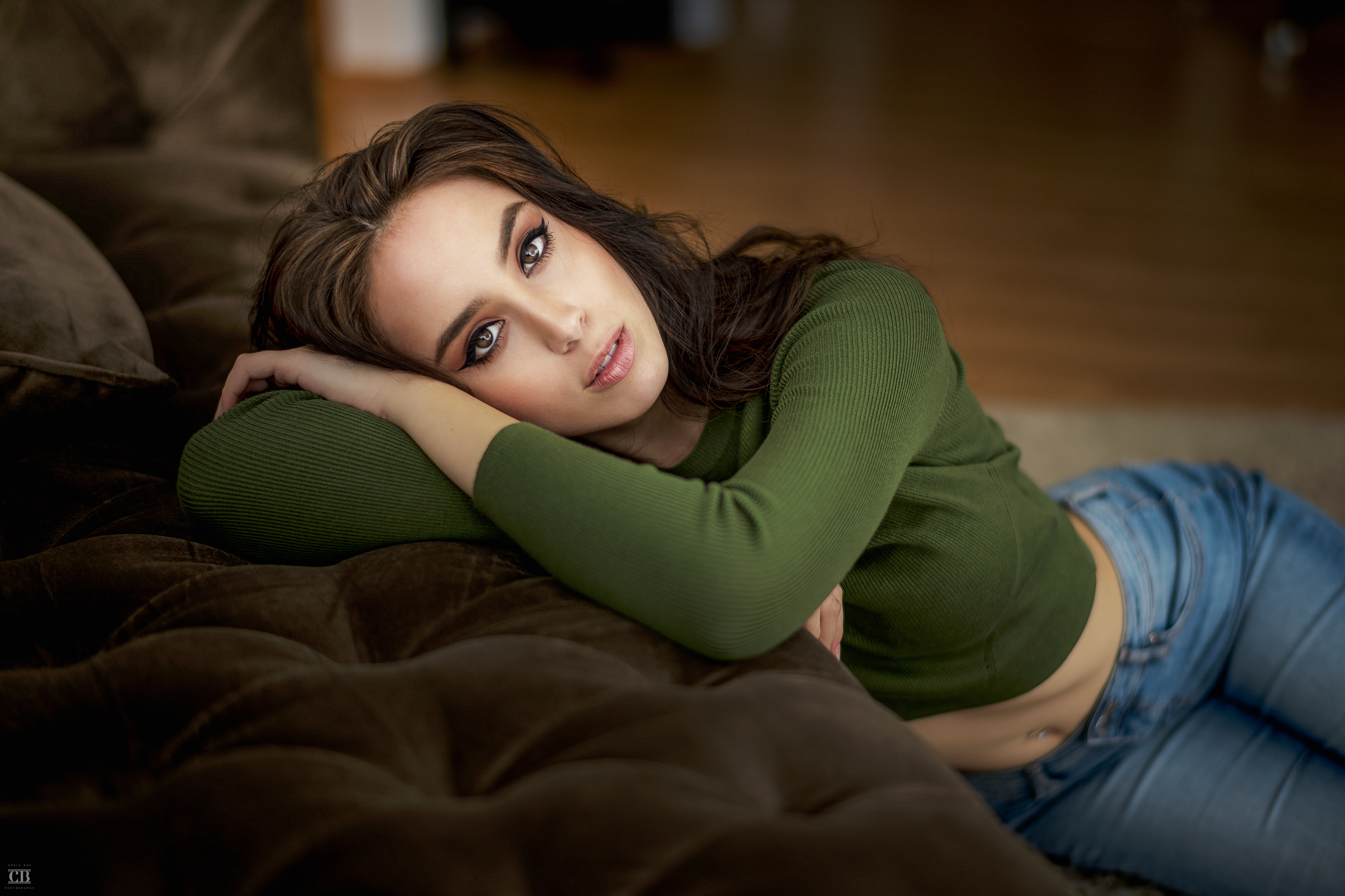 People 3840x2560 Anna Bous women brunette model long hair looking at viewer crop top sweater jeans belly pierced navel lying on side on the floor couch depth of field brown eyes indoors women indoors portrait Christopher Leone green sweater