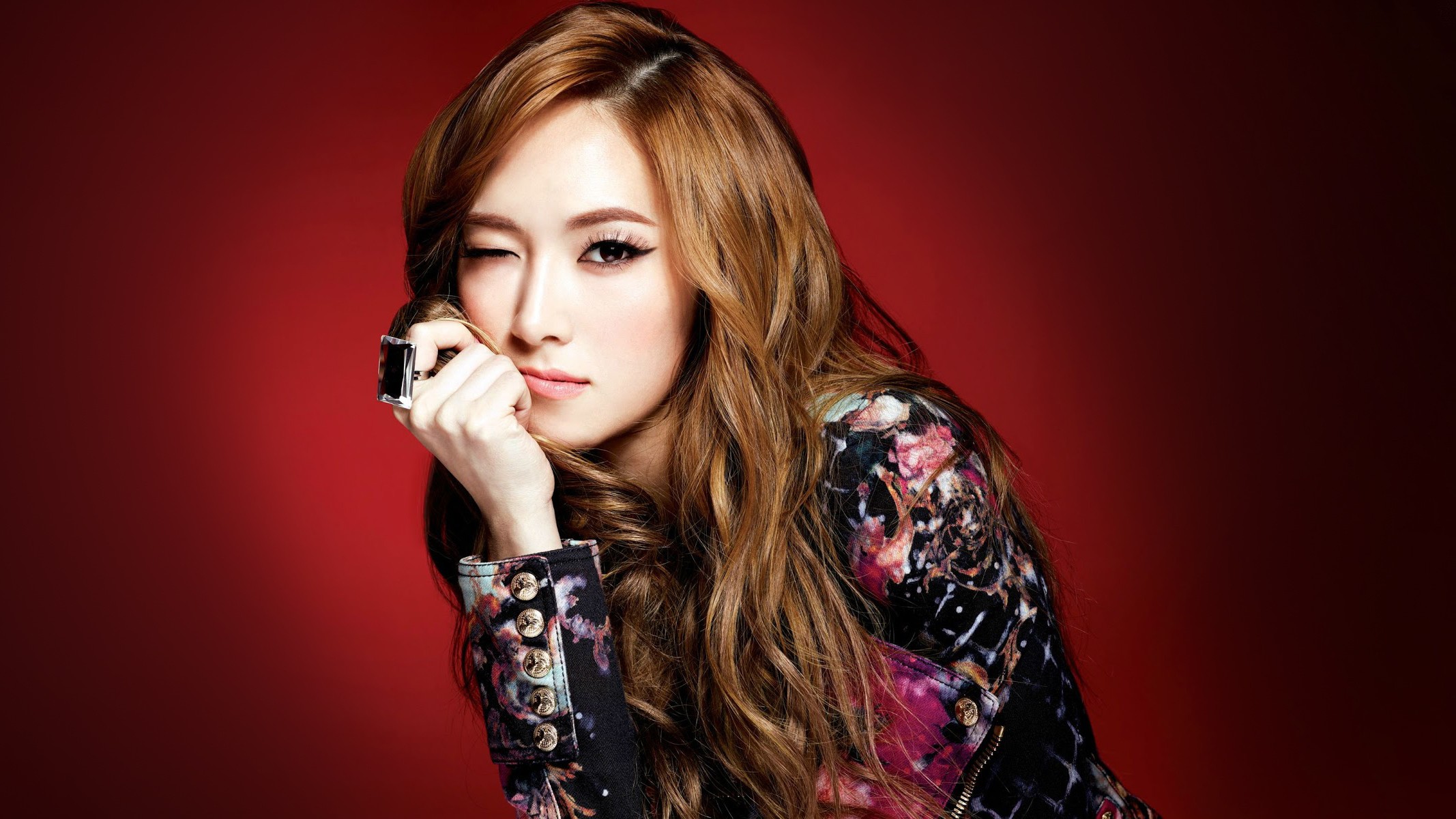 People 2134x1200 K-pop Jessica Jung wink Girls' Generation Asian women redhead long hair wavy hair looking at viewer hand on face red background simple background one eye closed