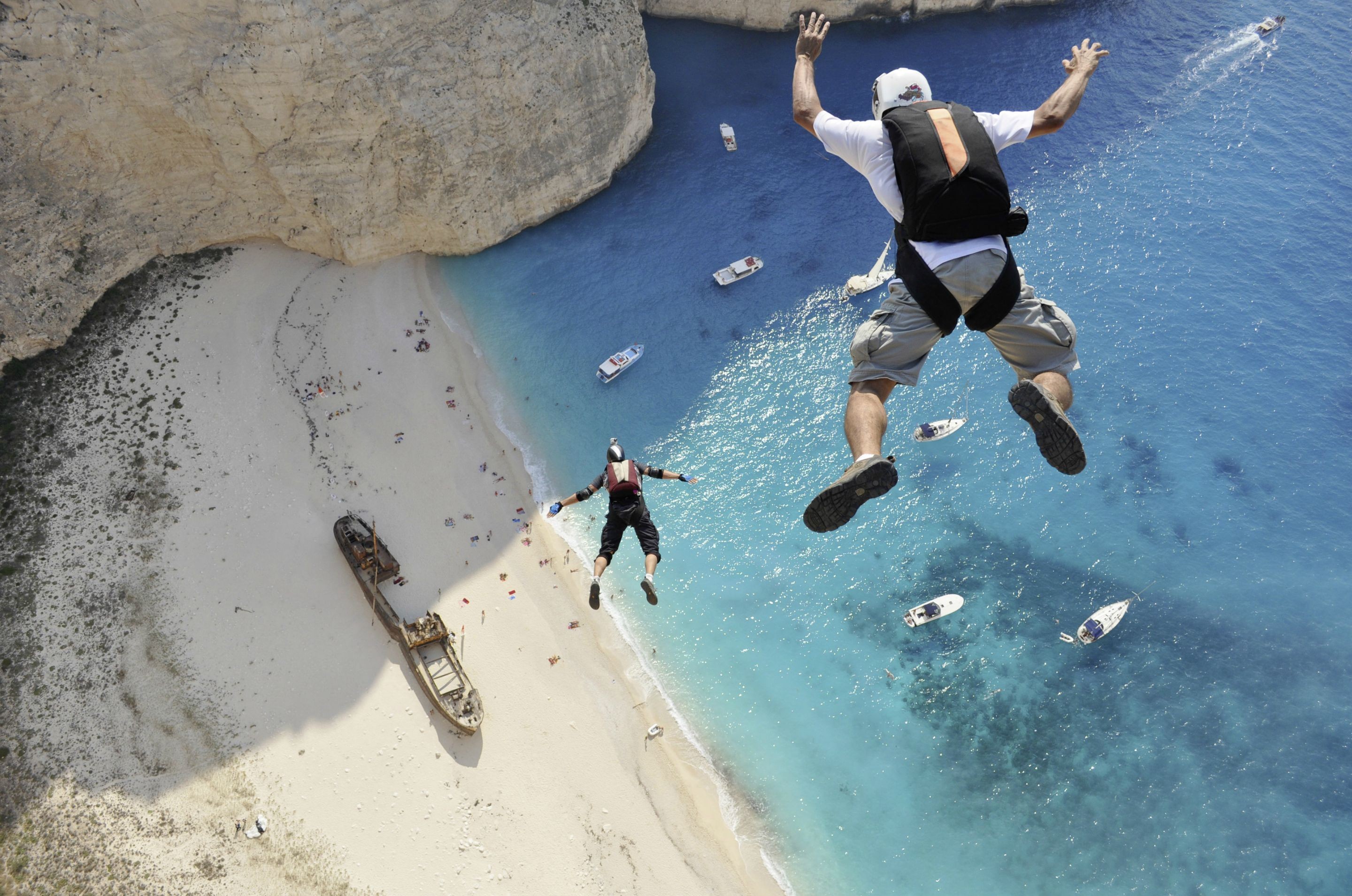 People 2880x1910 men sport jumping aerial view sand helmet beach sea rocks boat sunlight Greece parachutes