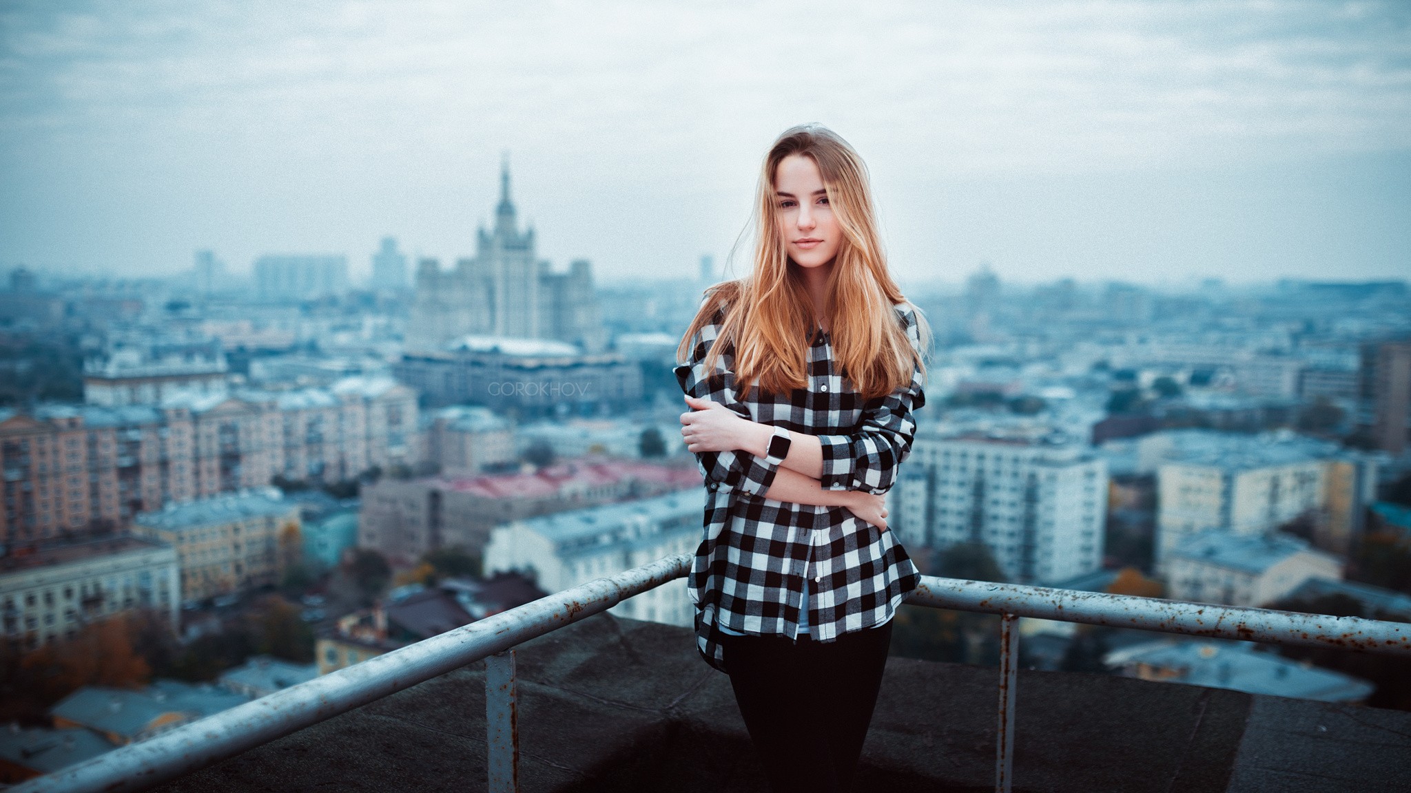 People 2048x1152 Maryana Ro women blonde model portrait cityscape Ivan Gorokhov plaid shirt arms crossed balcony rooftops Moscow standing black pants ombre hair hair in face watermarked Russia