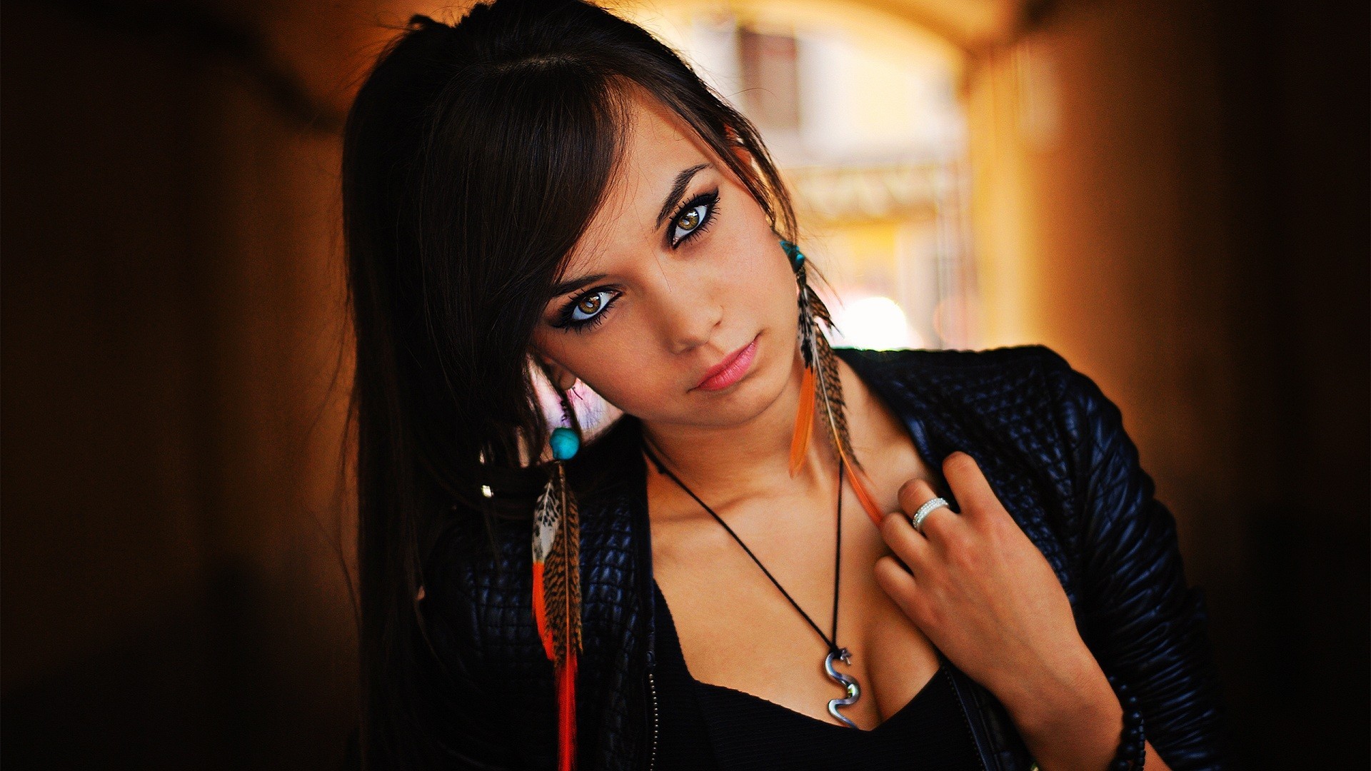 People 1920x1080 feathers dark hair black outfits women hazel eyes jacket cleavage model face portrait long hair looking at viewer necklace black clothing leather jacket tunnel rings smoky eyes makeup black hair