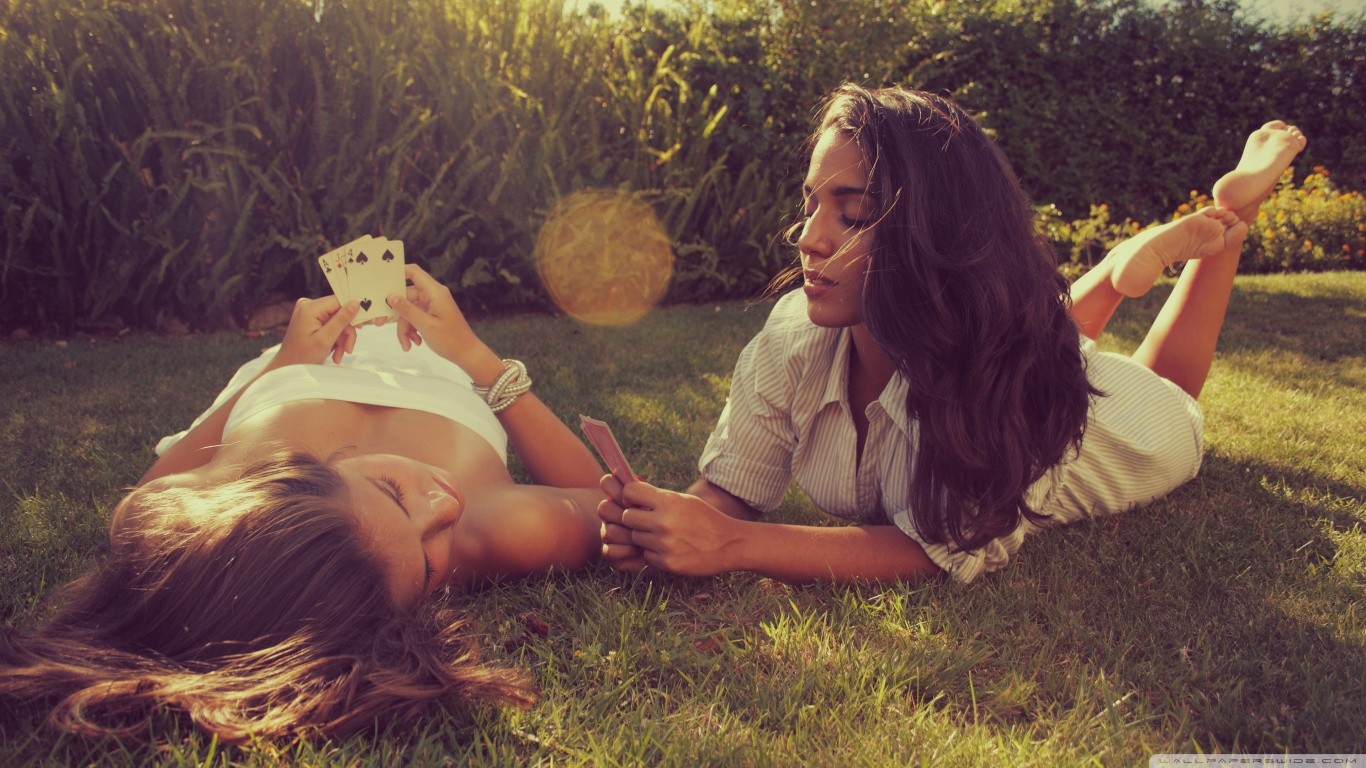 People 1366x768 closed eyes women women outdoors cards lying down two women playing cards grass plants lying on front dark hair barefoot outdoors