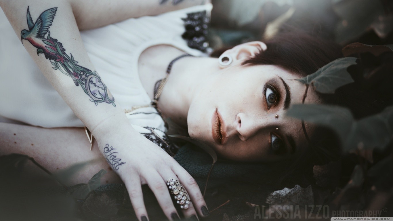 People 1366x768 women nature Alessia Izzo brunette tattoo pierced nose smoky eyes lying down pale inked girls red lipstick women outdoors outdoors