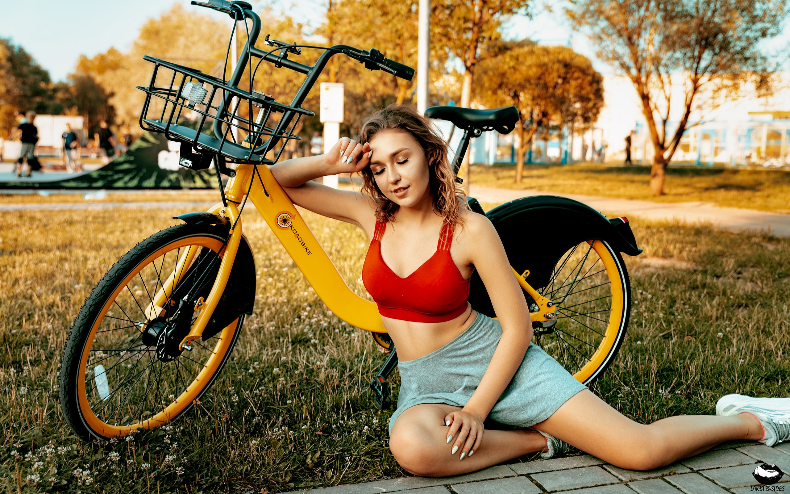 People 2560x1600 women sitting closed eyes smiling sneakers sportswear grass trees bicycle women with bicycles brunette socks white socks short socks on the ground white sneakers wavy hair bare midriff sports bra shorts shoes parted lips depth of field watermarked Lakbi B-Sides