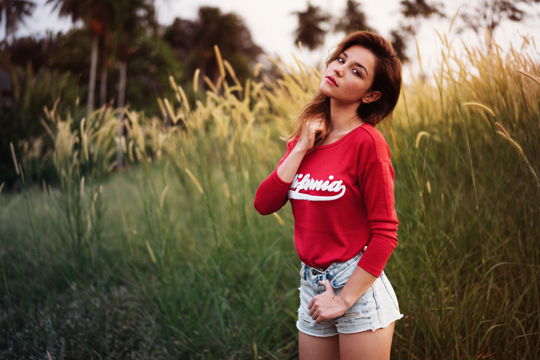 People 2048x1365 women brunette jean shorts looking at viewer Paul Toma grass red clothing hands in hair sweatshirts