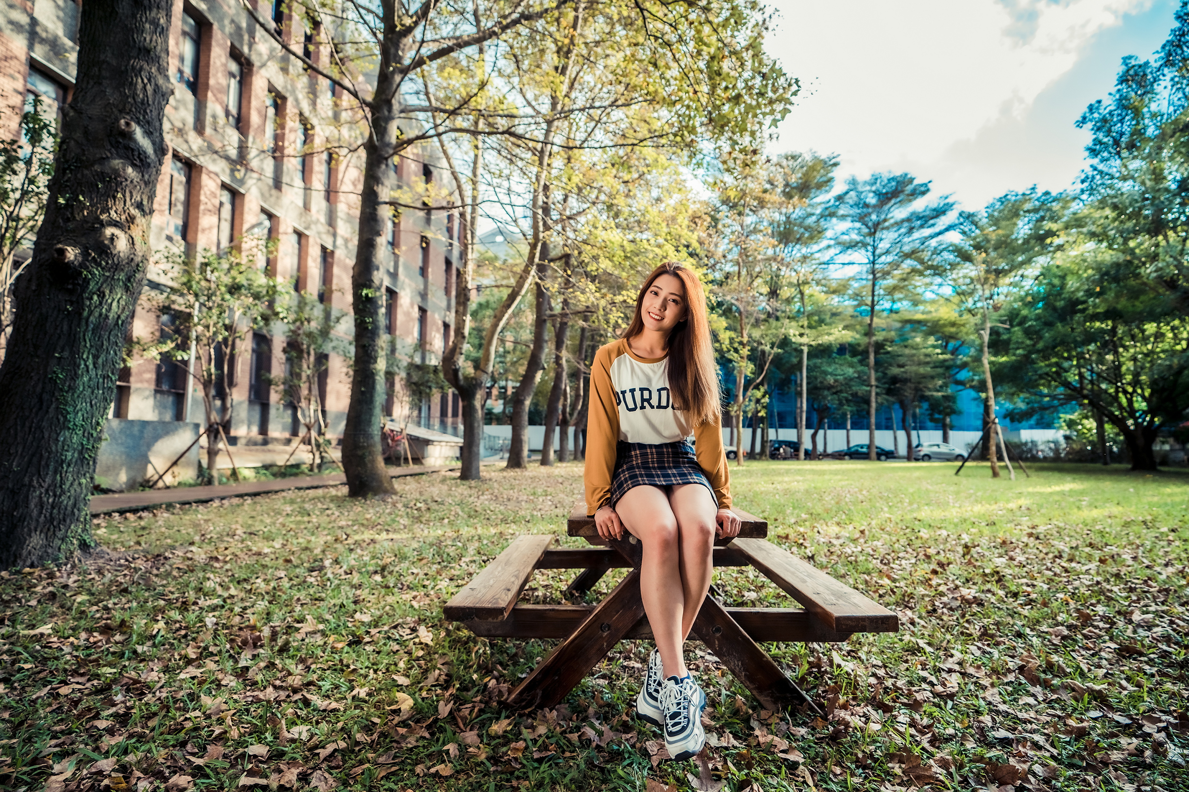 People 3840x2561 Asian women model long hair brunette sitting table bench park building leaves grass trees pullover skirt sneakers sweatshirts women outdoors