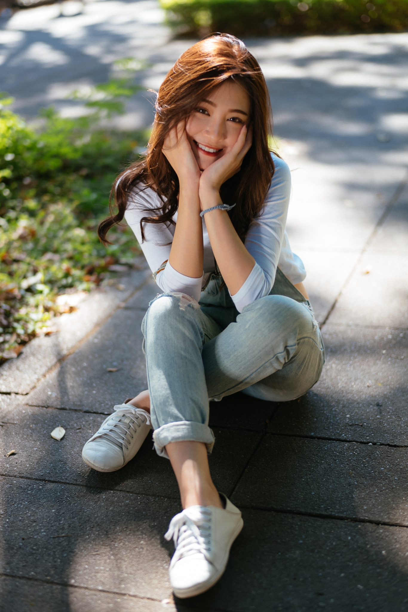 People 1366x2048 women Asian model brunette looking at viewer portrait display outdoors overalls denim white tops sitting touching face smiling legs crossed sidewalks depth of field women outdoors photography