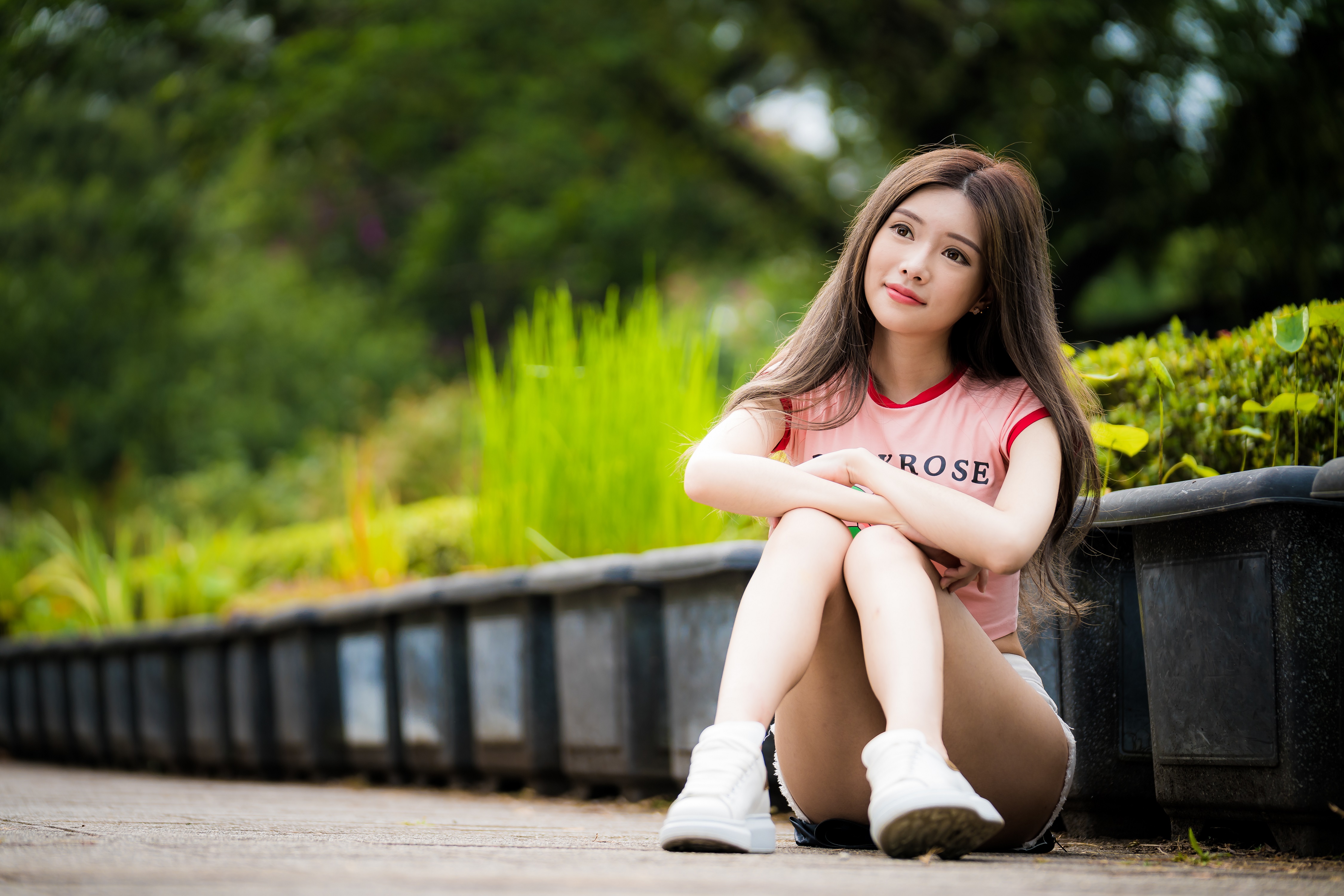 People 4500x3001 women model Asian brunette long hair looking away sitting arms crossed T-shirt jean shorts sneakers bokeh plants on the floor smiling outdoors women outdoors red lipstick