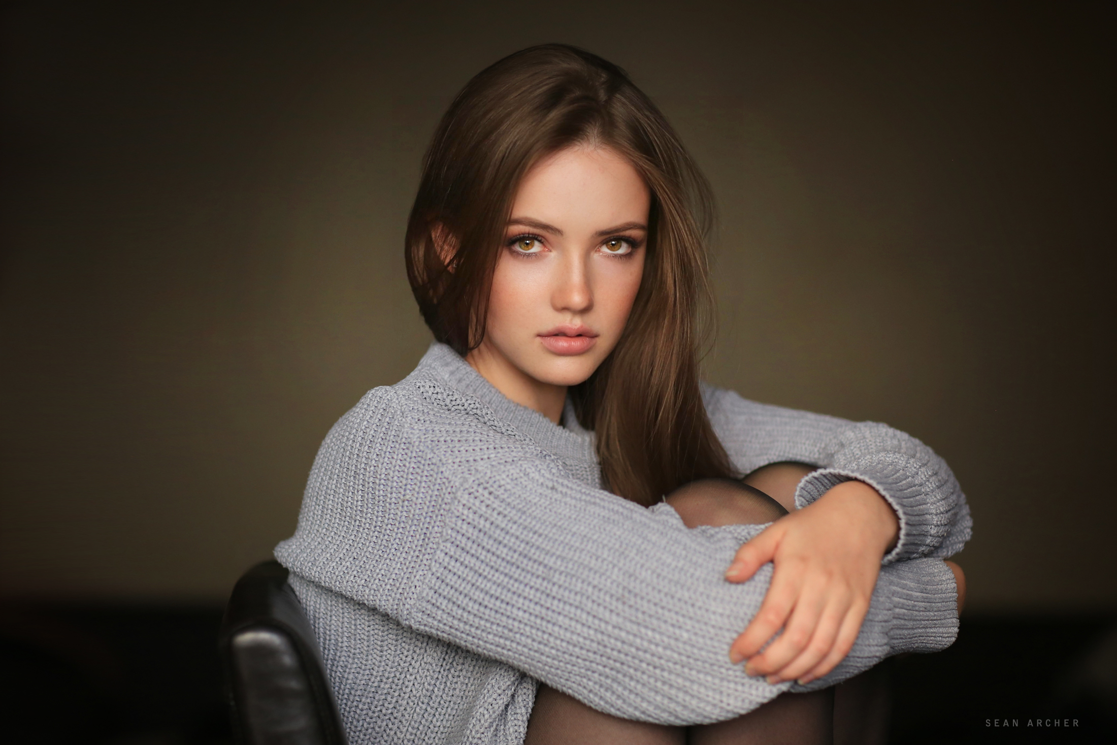 People 2200x1467 women glamour juicy lips looking at viewer long hair women indoors brunette brown eyes long sleeves arms crossed sweater watermarked sitting bent legs holding leg(s) pantyhose chair knit fabric Sean Archer