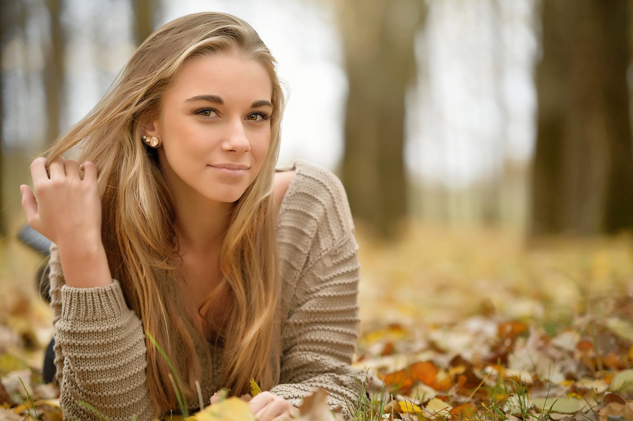People 2048x1363 women model blonde long hair looking at viewer sweater women outdoors face fall fallen leaves depth of field lying on front brown eyes hands in hair smiling people young women pulling hair nature