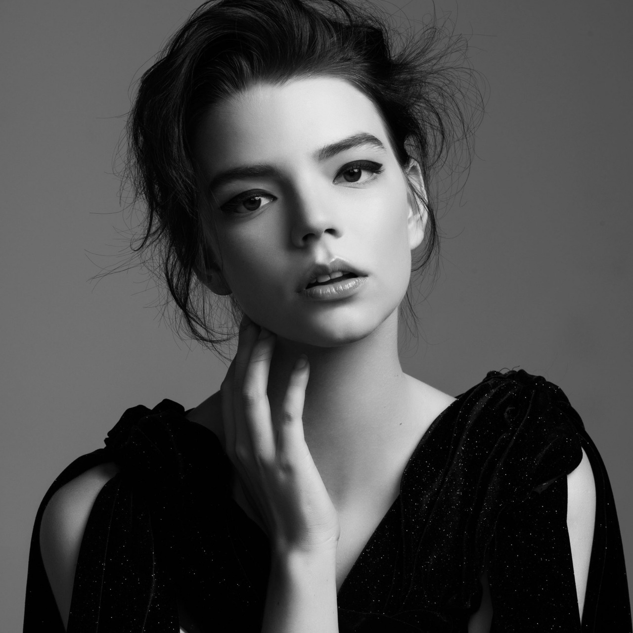 People 1280x1280 touching face caressing women open mouth dark hair black dress messy hair looking at viewer face monochrome celebrity actress gray background simple background dress makeup Anya Taylor-Joy  portrait studio