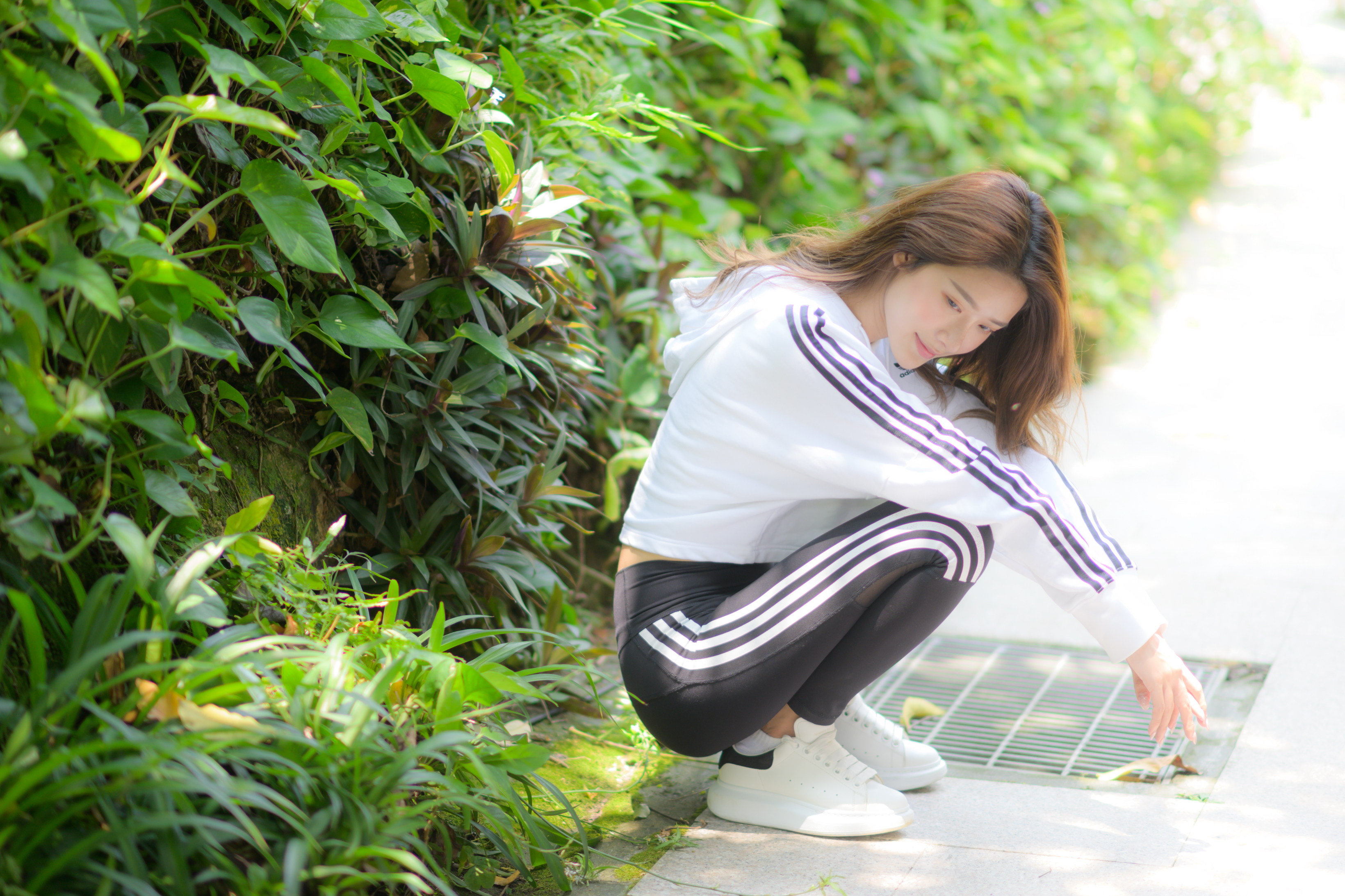 People 3280x2187 Asian model women long hair brunette squatting sneakers jogging pants bushes sweatshirts hoods