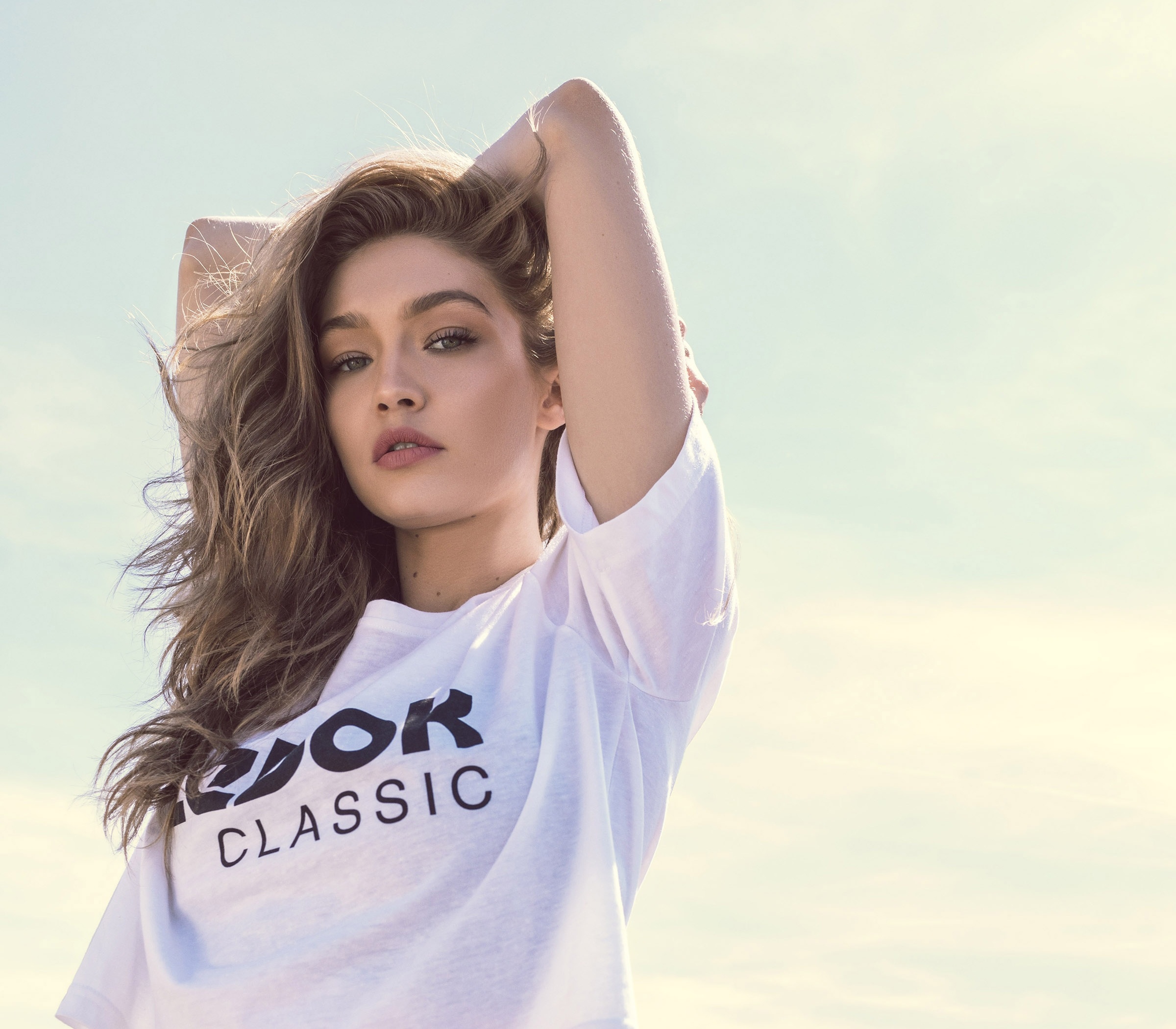 People 2400x2100 Gigi Hadid model women blonde blue eyes mouth lips lipstick T-shirt arms up looking at viewer white t-shirt celebrity arm(s) behind head moles parted lips simple background