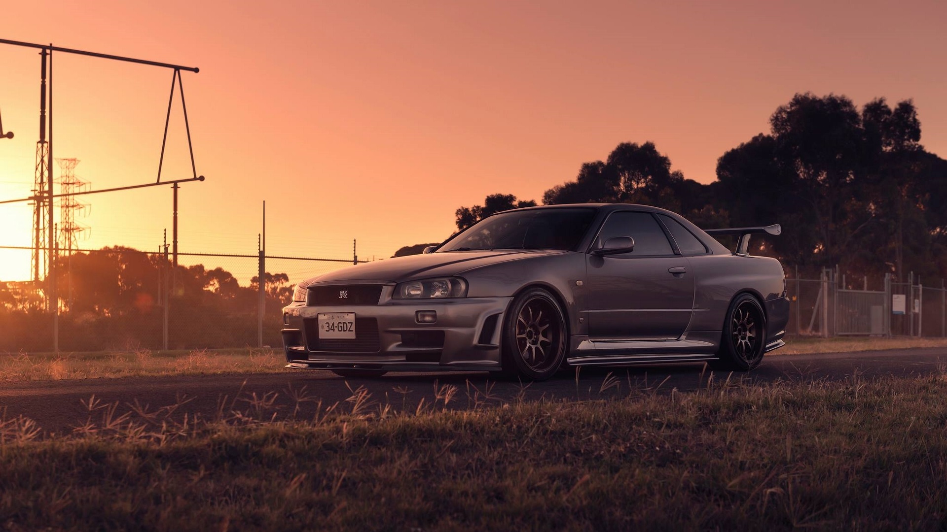 General 1920x1080 Nissan Skyline R34 Nissan Skyline Nissan Japanese cars car vehicle gray cars silver cars sunset road trees grass sports car outdoors PT works