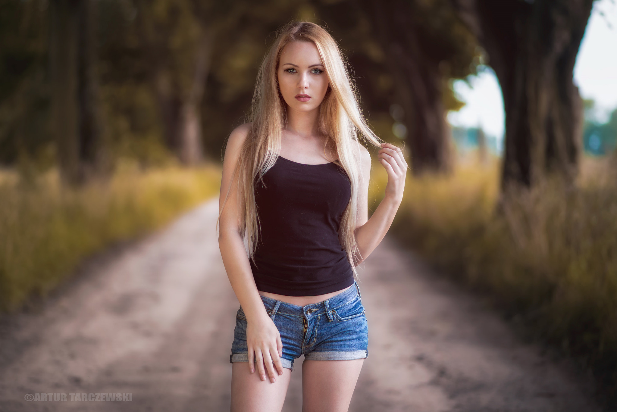 People 2048x1368 women blonde jean shorts depth of field trees women outdoors Artur Tarczewski Oliwia Maciąg Polish touching hair holding hair looking at viewer Polish women black top tank top Polish model frontal view watermarked