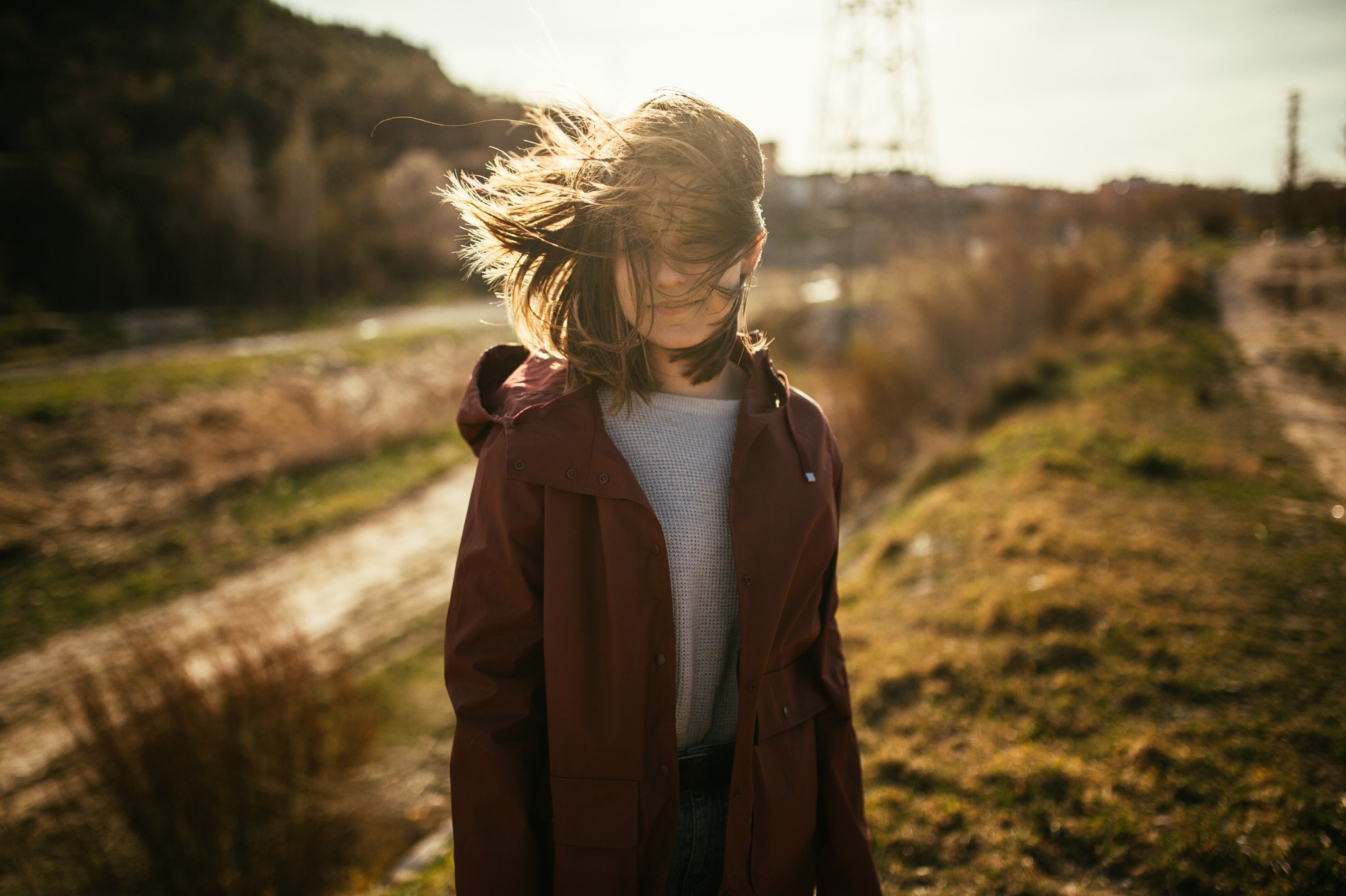 People 2048x1365 brunette model women looking away plants trees mountains path tower smiling sunlight photography wind jacket hoods brown coat windy hair in face road shoulder length hair open coat women outdoors hair blowing in the wind white sweater