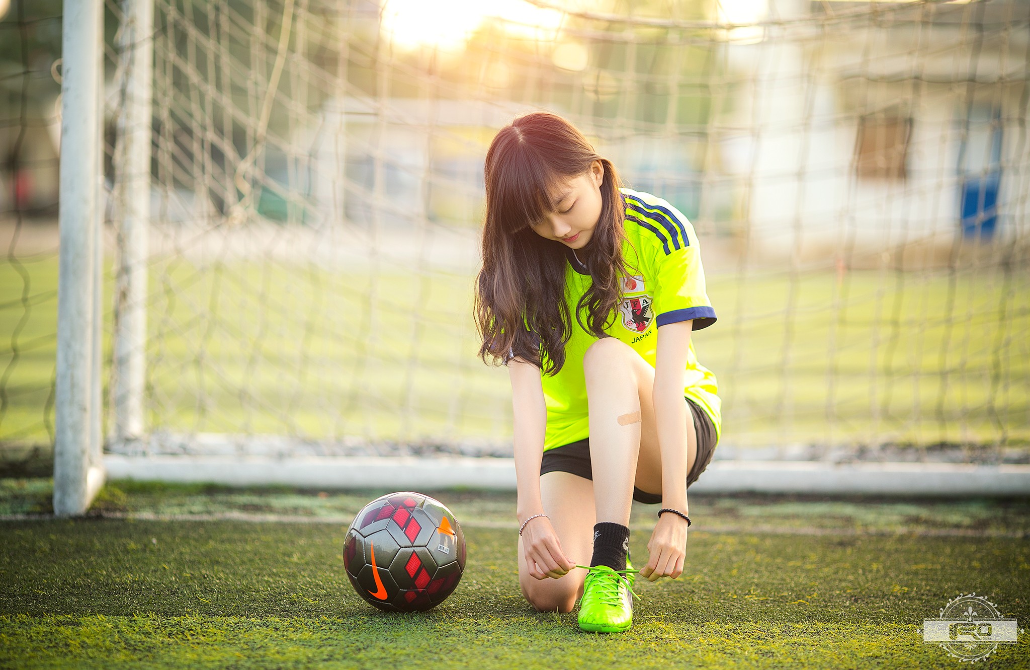 People 2048x1331 soccer soccer girls women Asian brunette sport ball kneeling long hair soccer field women outdoors model green shoes