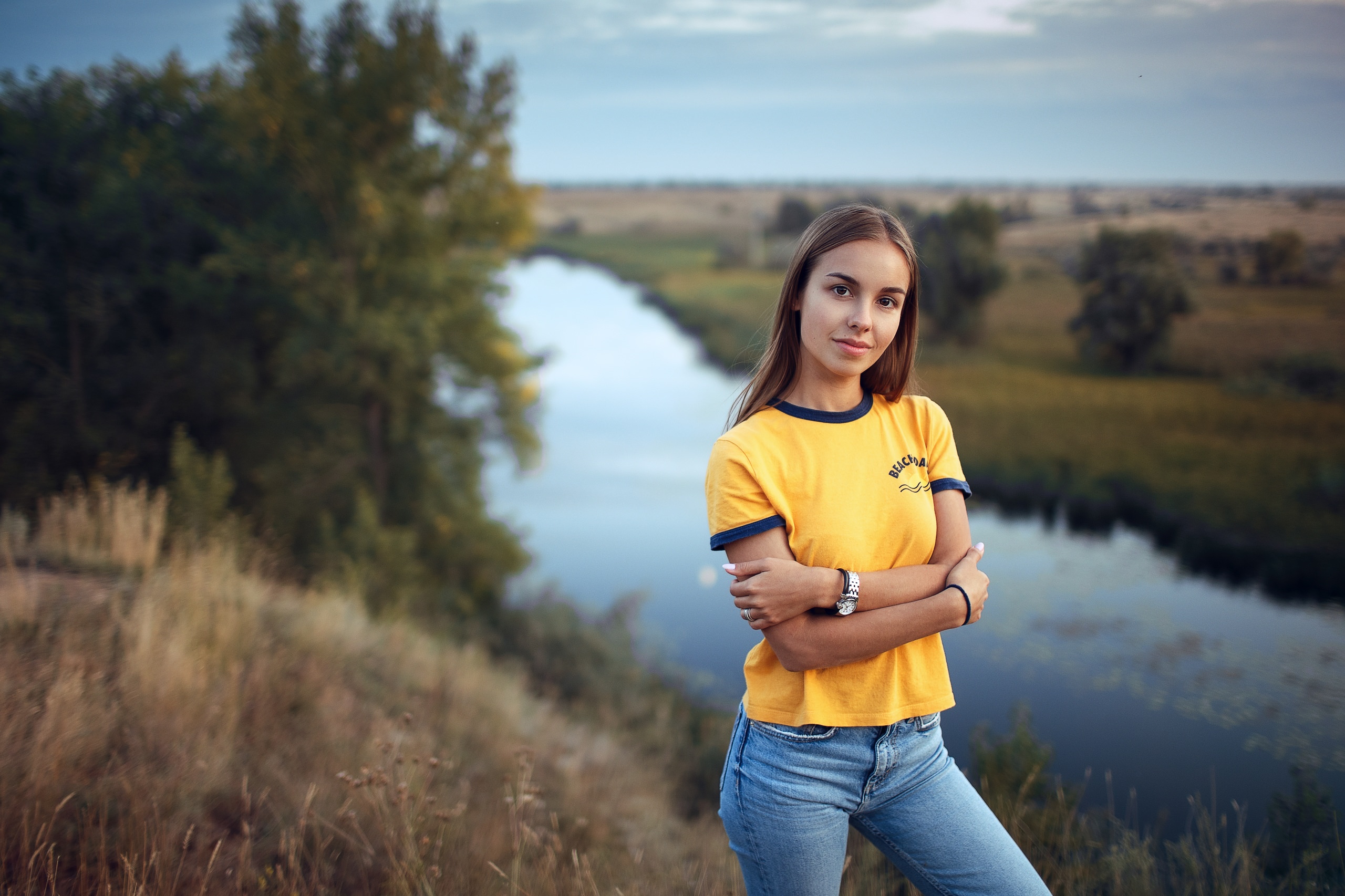 People 2560x1706 women yellow t-shirt river nature jeans watch arms crossed sky women outdoors smiling T-shirt