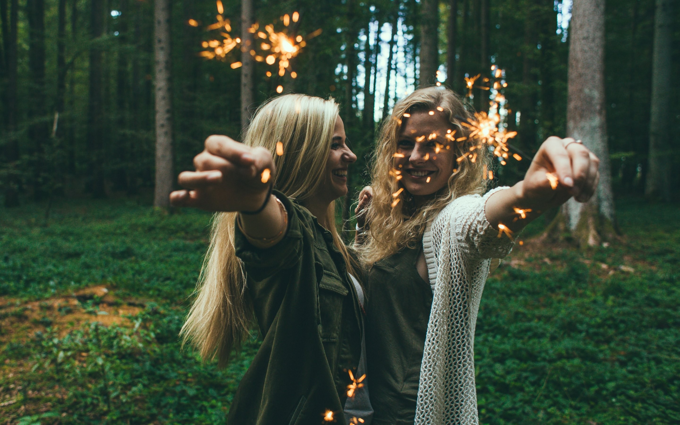 People 2880x1800 blonde women sunlight trees leaves looking at viewer sparkler burning smiling women outdoors long hair model happy two women