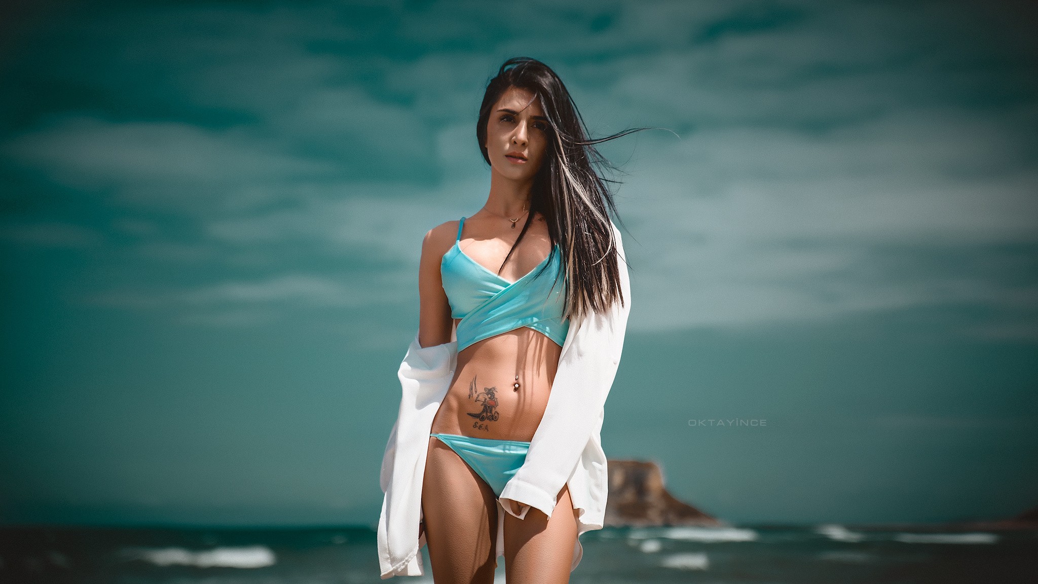 People 2048x1152 women tattoo bikini pierced navel sky sea OKTAY İNCE watermarked model belly inked girls black hair standing looking into the distance blue bikini swimwear long hair