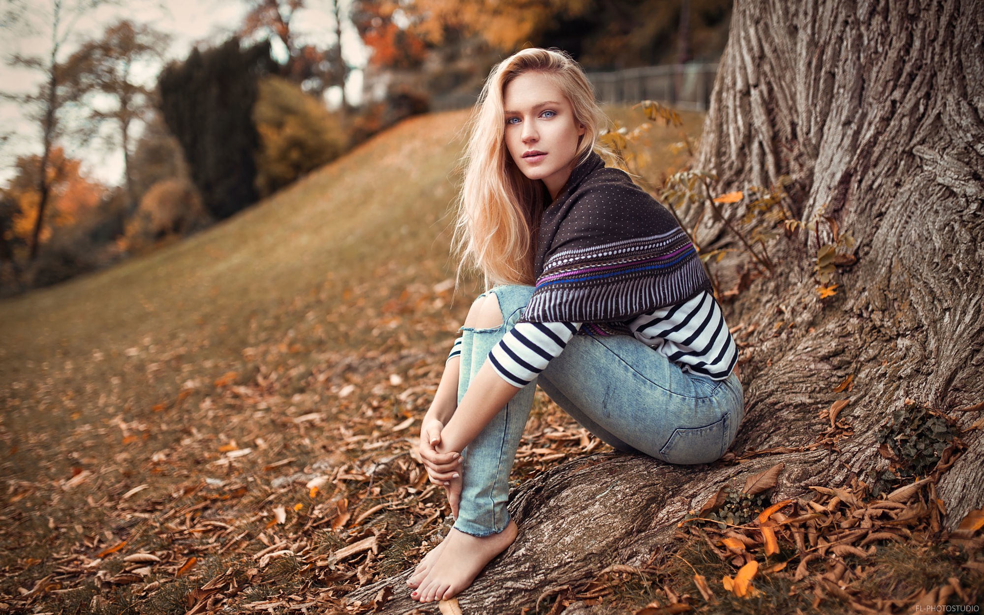 People 2000x1250 trees women outdoors blonde women blue eyes torn jeans Eva Mikulski model long hair depth of field barefoot looking at viewer sitting Lods Franck outdoors torn clothes fallen leaves fall
