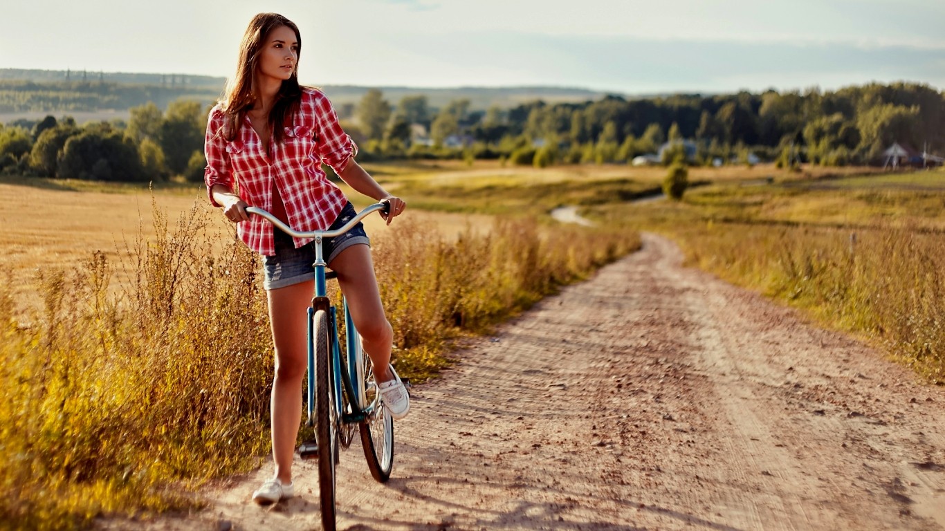 People 1366x768 women model bicycle women with bicycles vehicle path looking into the distance plaid shirt shirt plaid clothing legs brunette women outdoors landscape jean shorts sneakers road