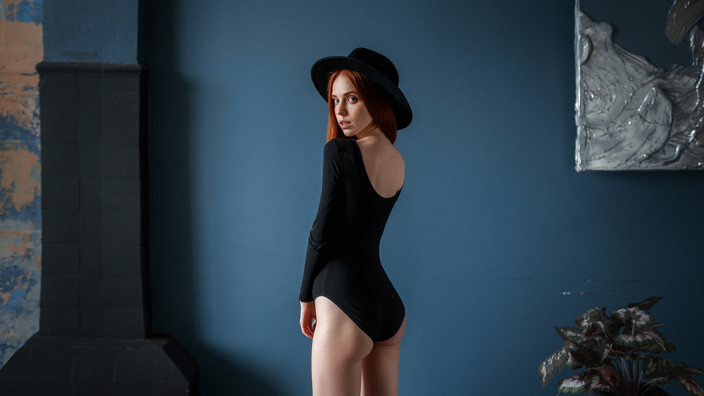 People 2453x1380 Yuri Demidov women hat redhead looking at viewer black clothing ass bodysuit wall bareback looking over shoulder black hat skinny model parted lips