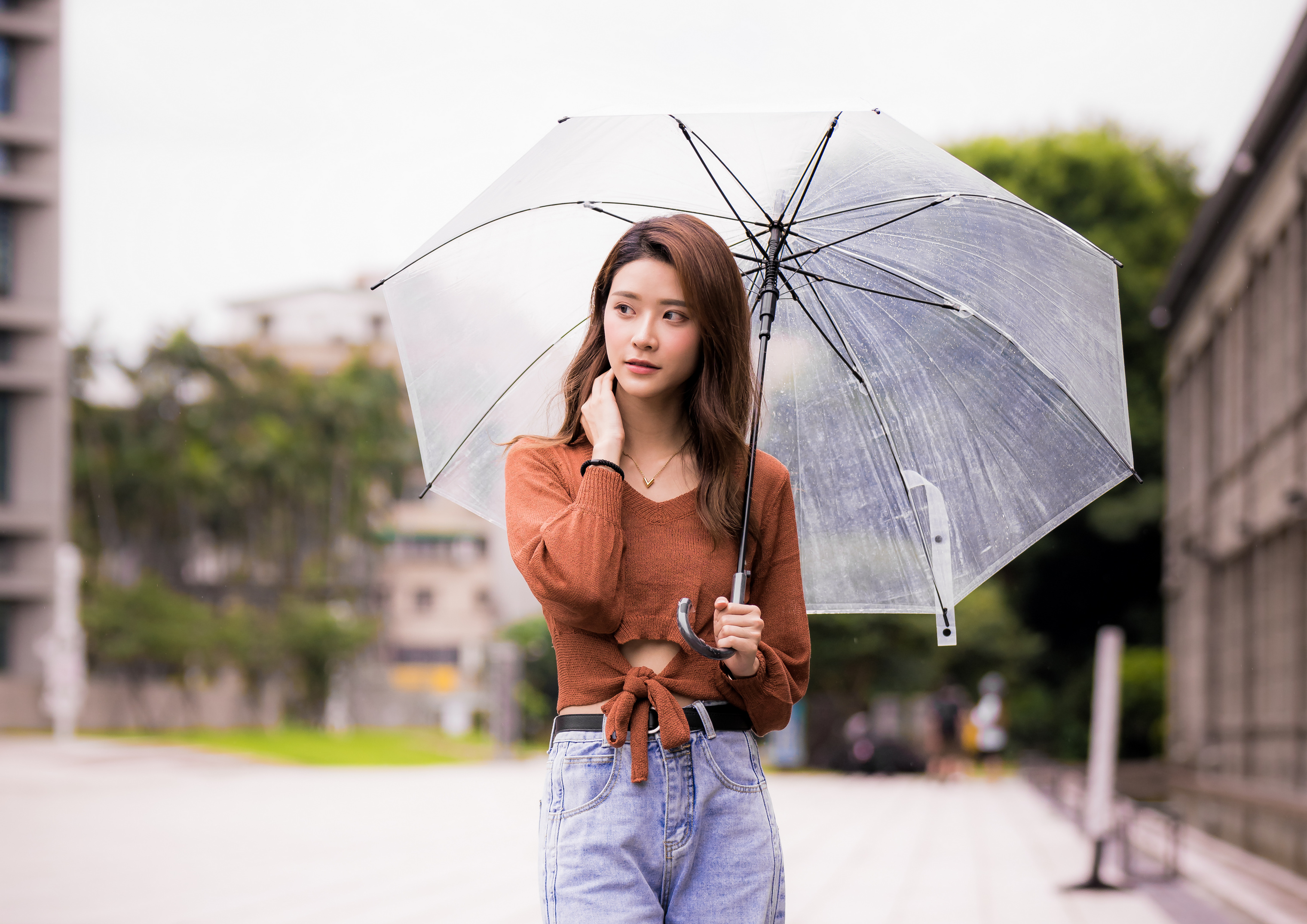 People 3041x2149 Asian model women long hair brunette jeans umbrella pullover depth of field trees grass building belt