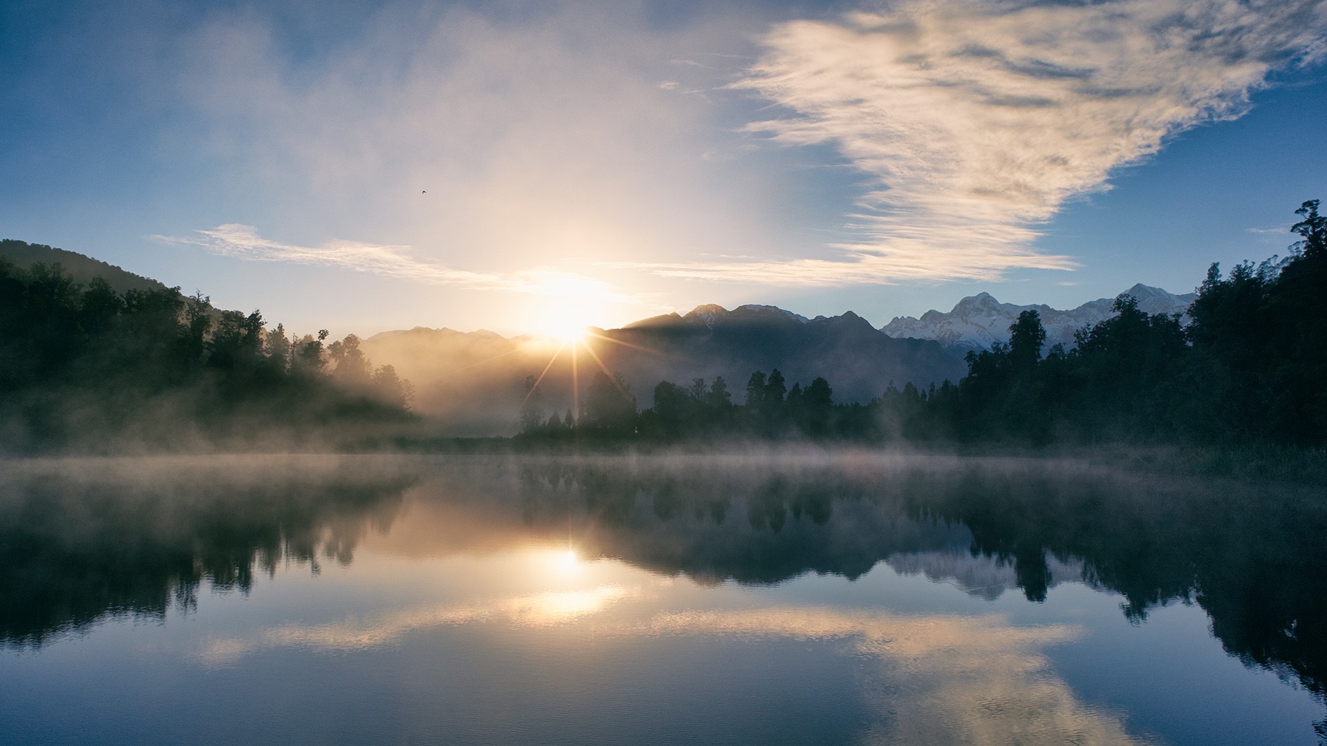General 1920x1080 nature landscape clouds sky water trees forest lake reflection sunrise sun rays mist mountains snowy mountain Lake Matheson New Zealand