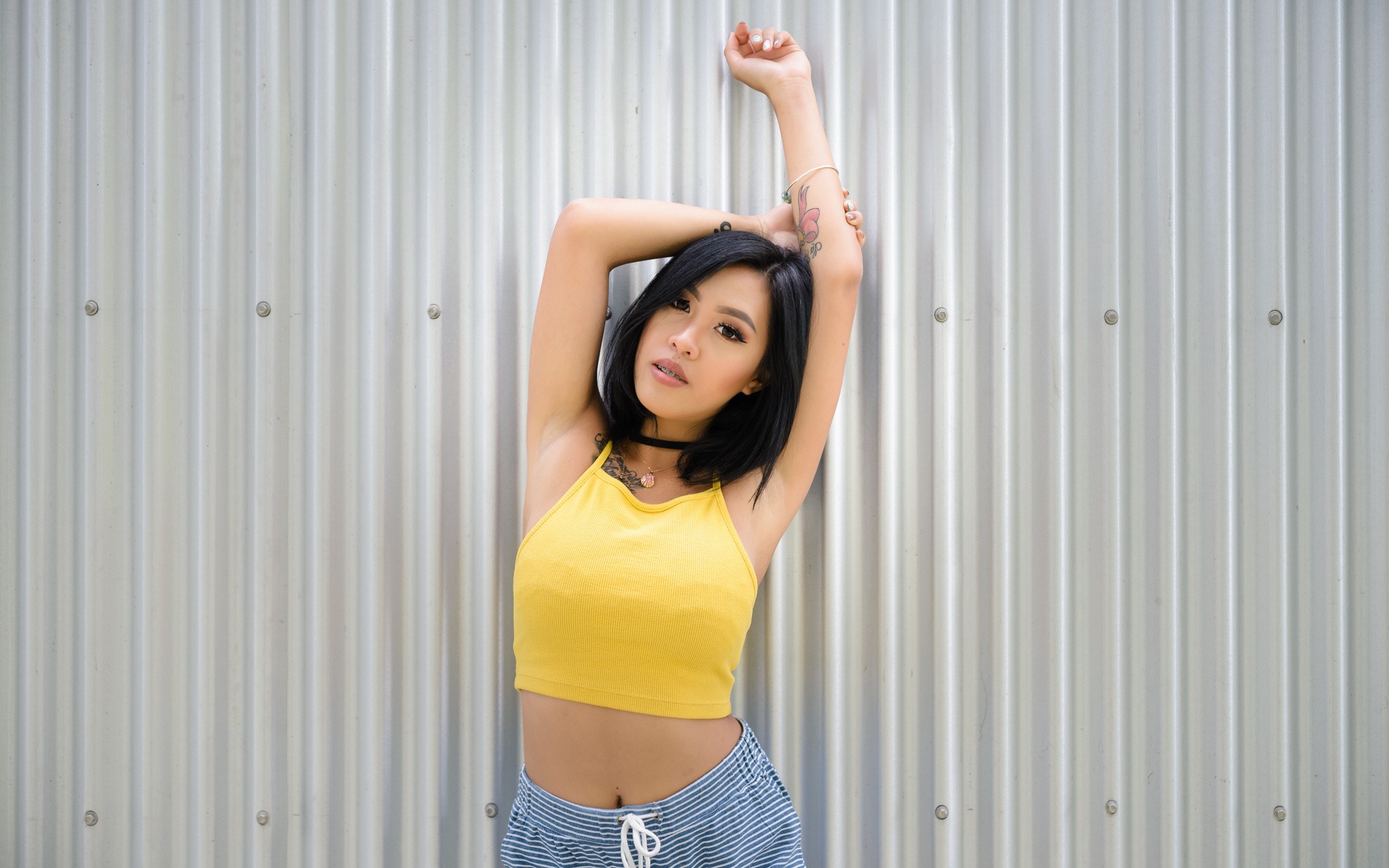 People 2048x1280 Gizel Ramos portrait arms up armpits wall tattoo women model belly black hair inked girls yellow tops looking at viewer