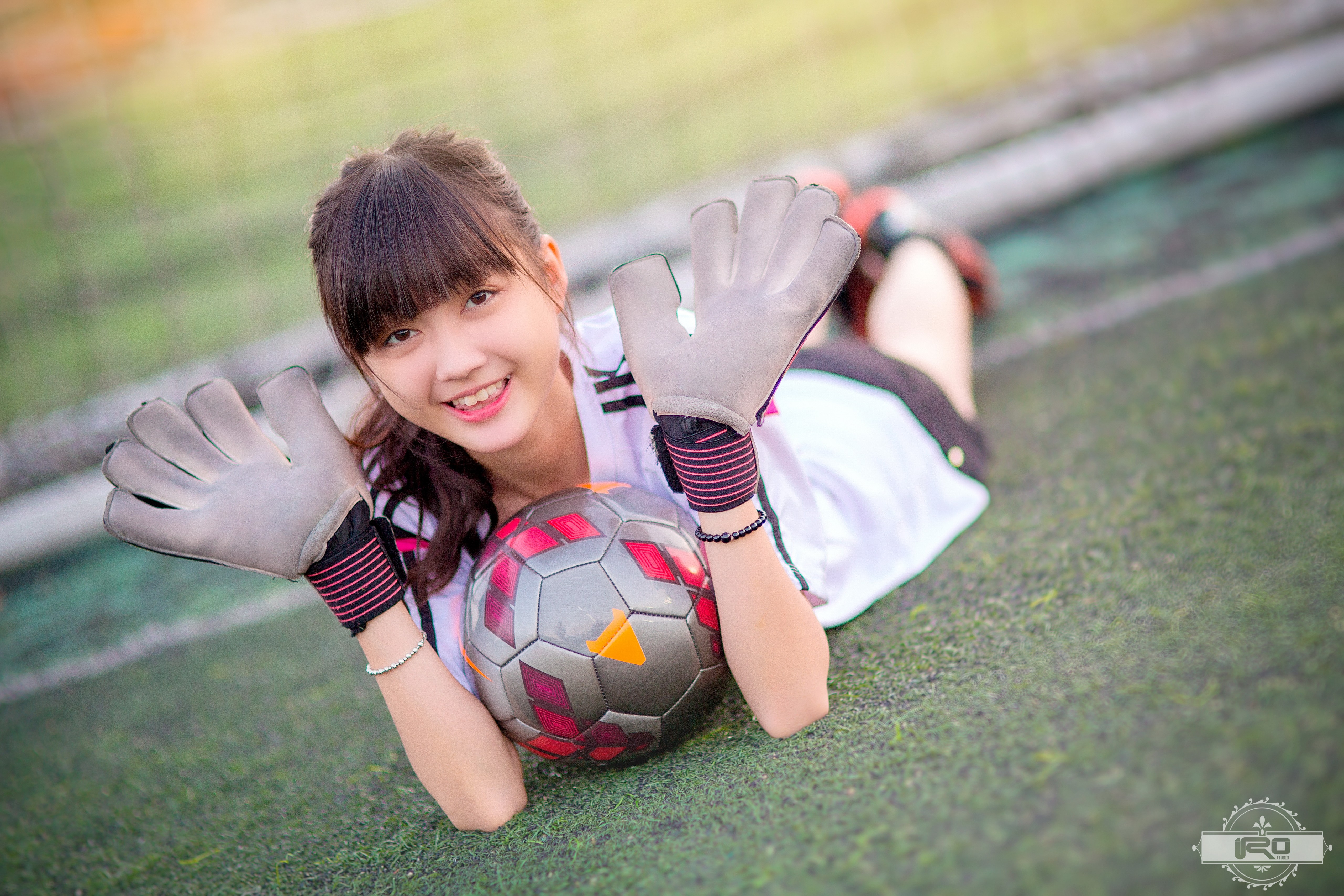 People 5120x3413 smiling ball lying on front women soccer field soccer girls gloves soccer ball Asian model grass women outdoors watermarked looking at viewer brunette
