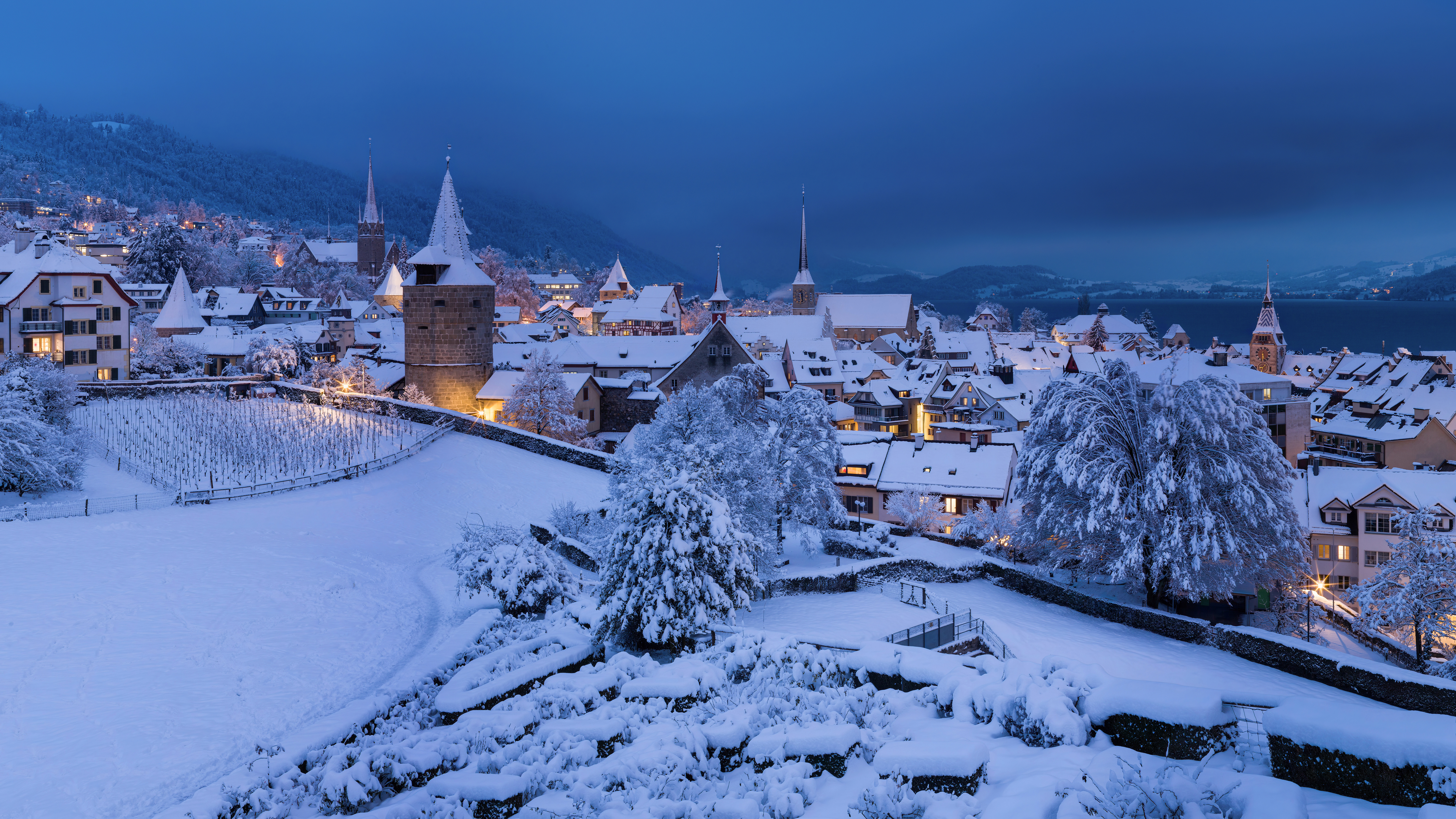 General 8192x4608 winter snow Switzerland photography church evening village rooftops snow covered trees sky city lights city cityscape building