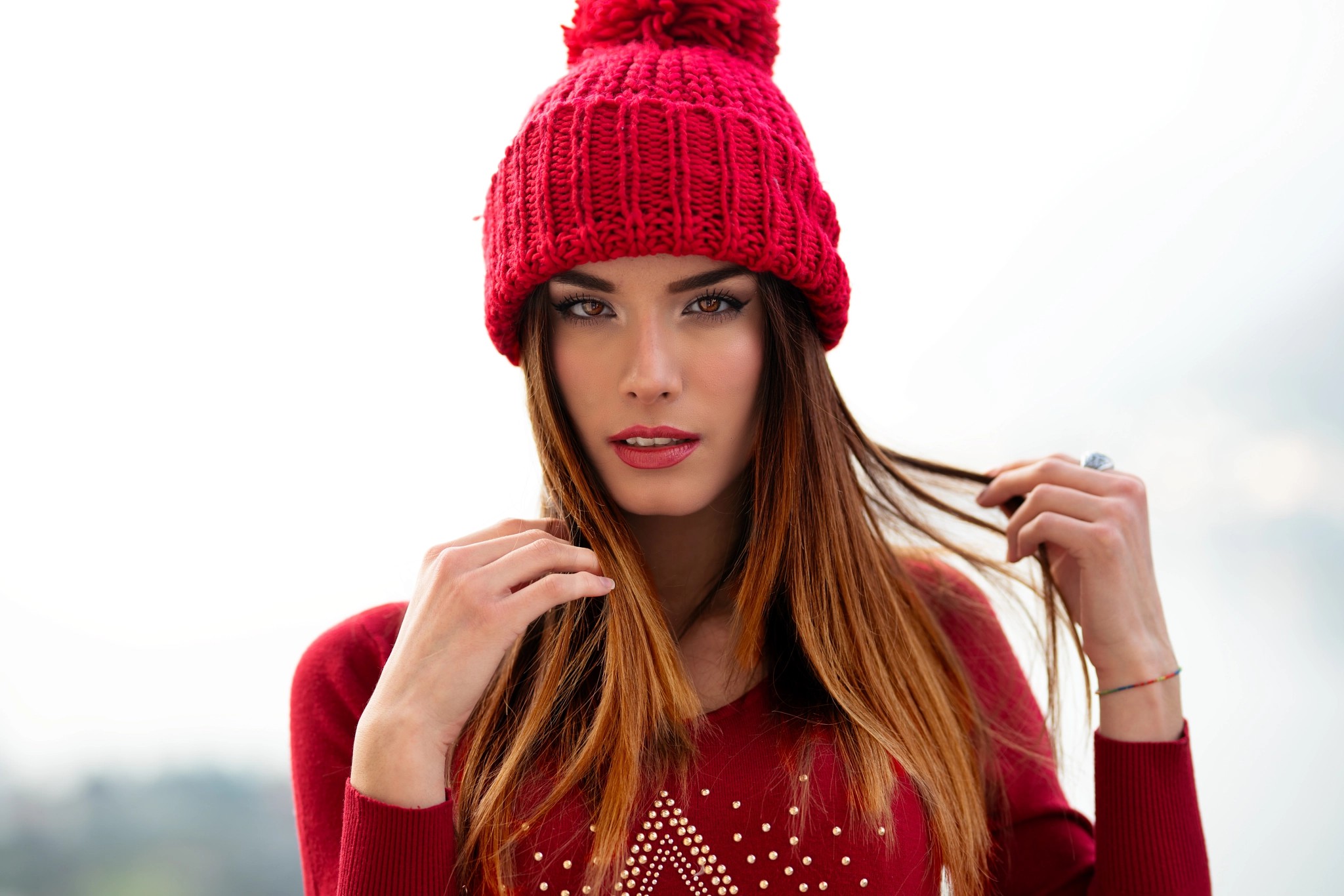 People 2048x1366 Marco Squassina women portrait looking at viewer face model bokeh women outdoors brunette holding hair brown eyes bonnet pink lipstick lipstick straight hair wool cap sweater red sweater Marialaura Caccia Red cap