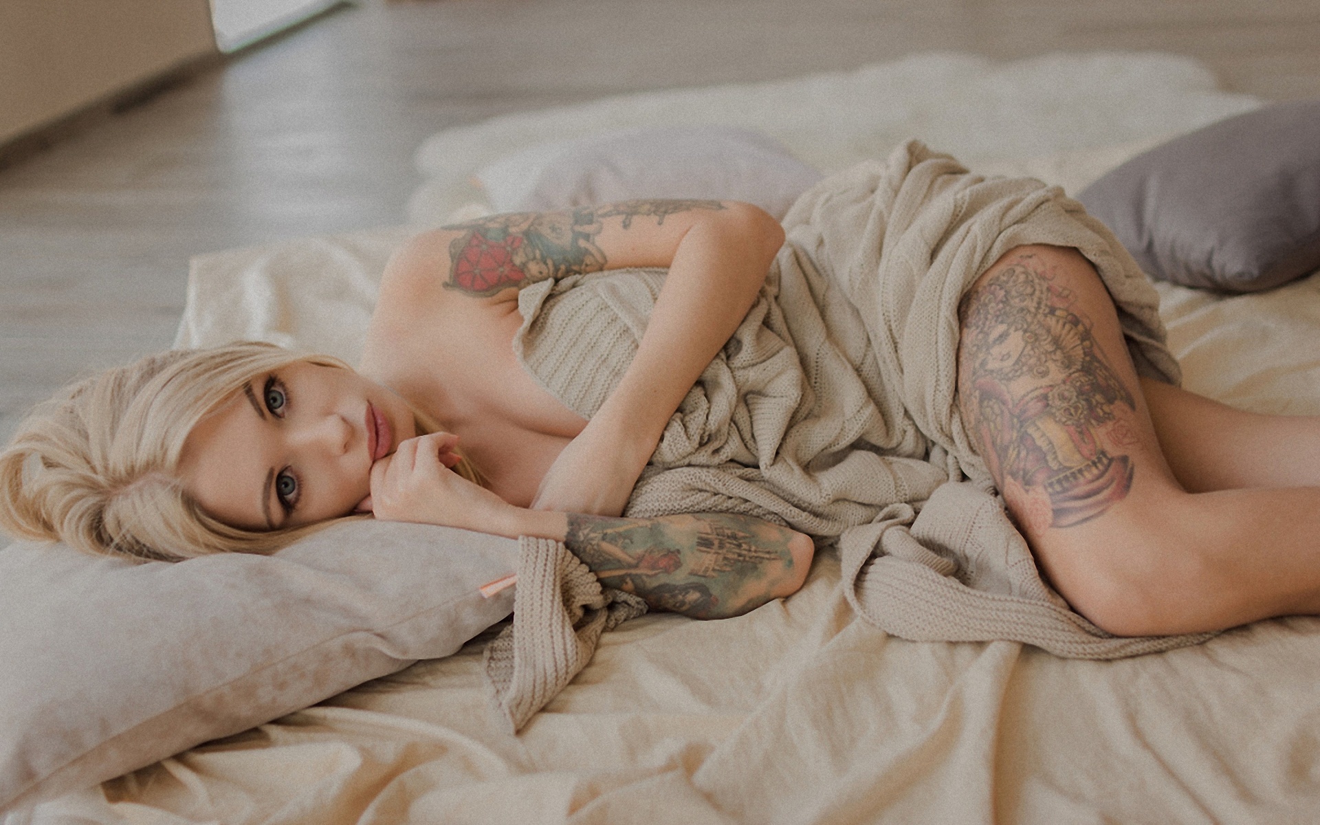 People 1920x1200 women model long hair blonde dyed hair straight hair women indoors lying on side tattoo looking at viewer floor bokeh touching face pillow grey clothing natural light cleavage Maria Pazhina