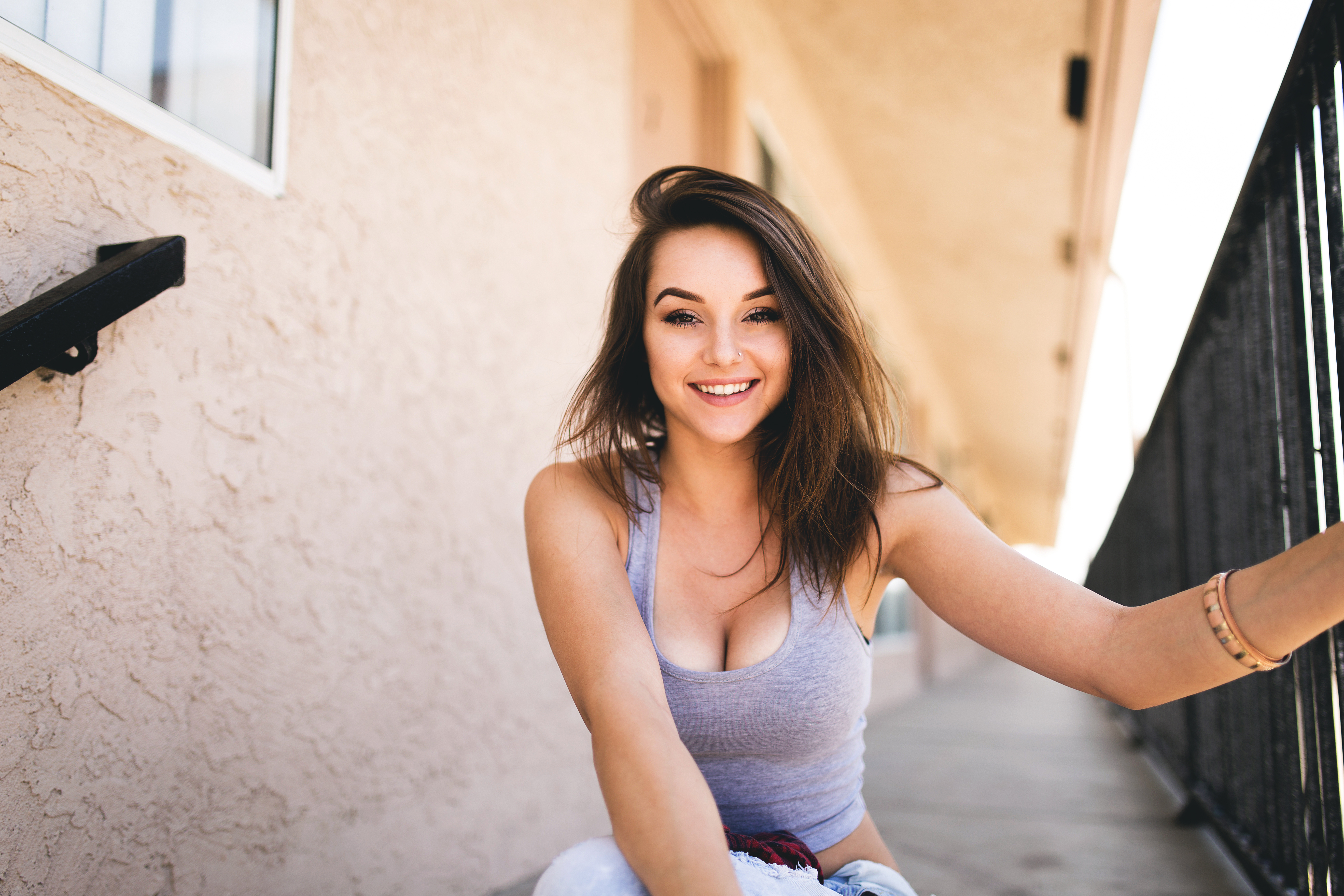 People 5472x3648 women model portrait smiling looking at viewer grey tops sitting outdoors women outdoors depth of field cleavage brunette messy hair happy frontal view