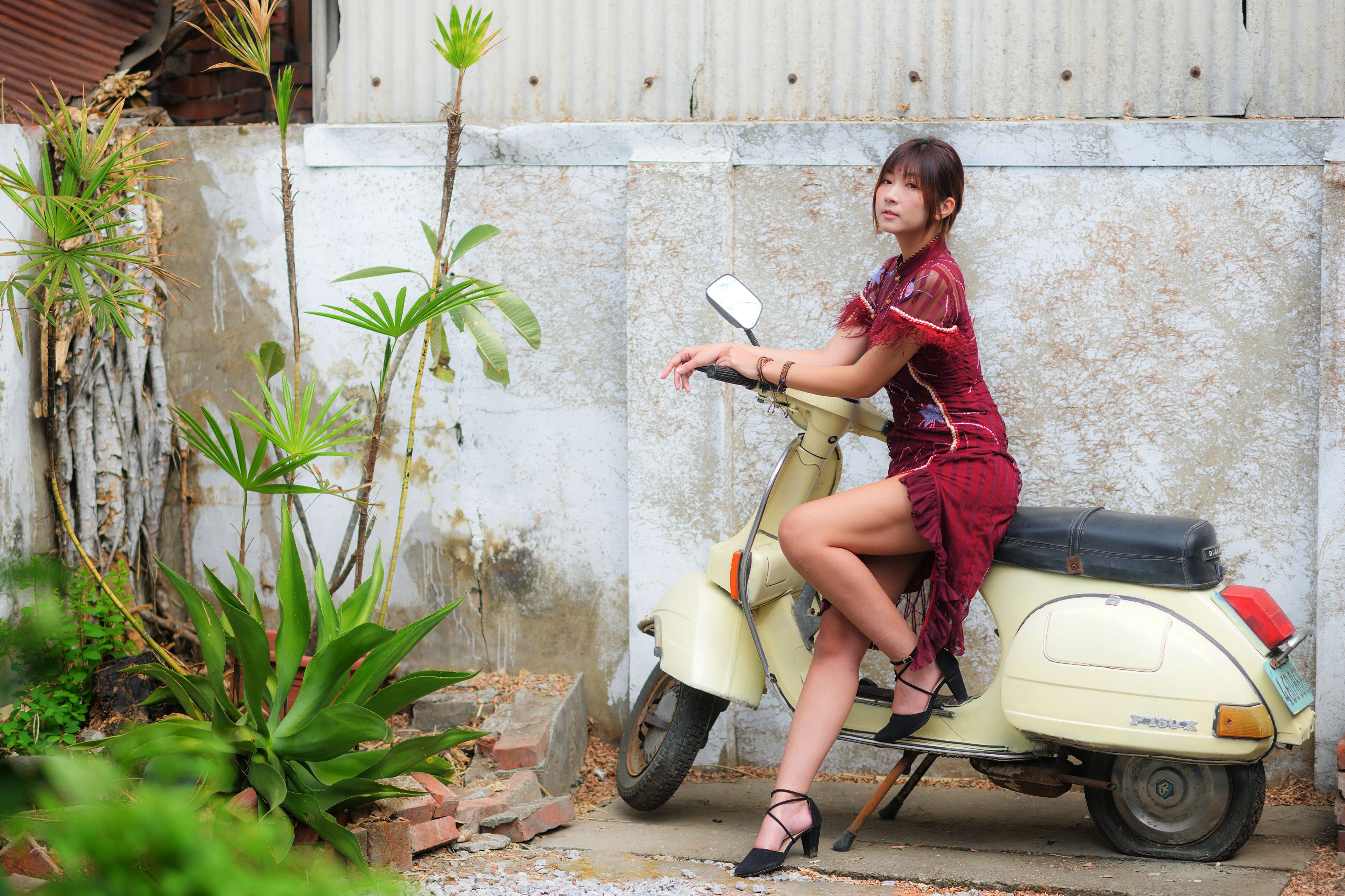 People 3600x2400 Asian model women long hair brunette sitting Vespa dress ponytail plants wall shoes women outdoors women with scooters scooters legs red clothing black heels looking at viewer