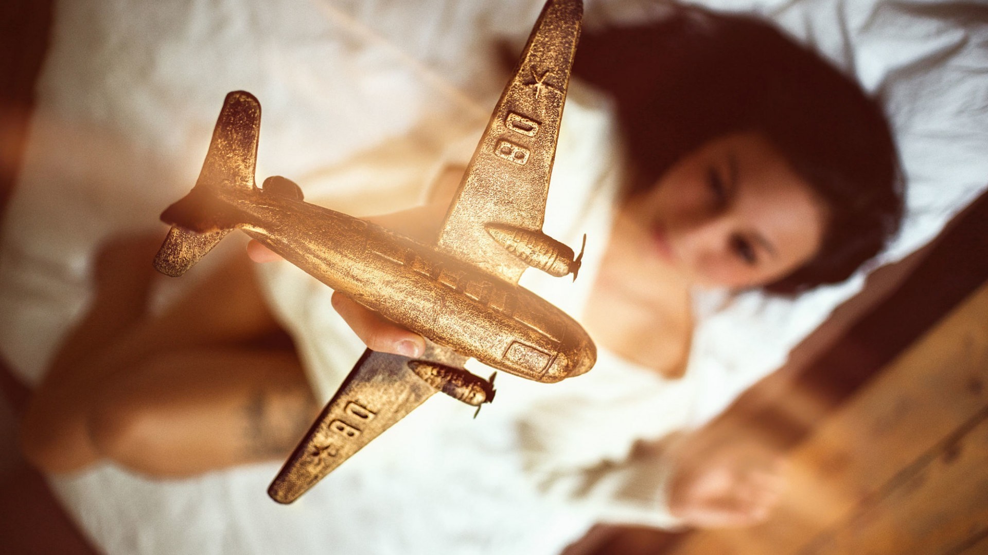 People 1920x1080 women model brunette long hair looking at viewer airplane miniatures lying on back in bed white tops legs depth of field tattoo blurred toys top view vehicle women indoors indoors closeup