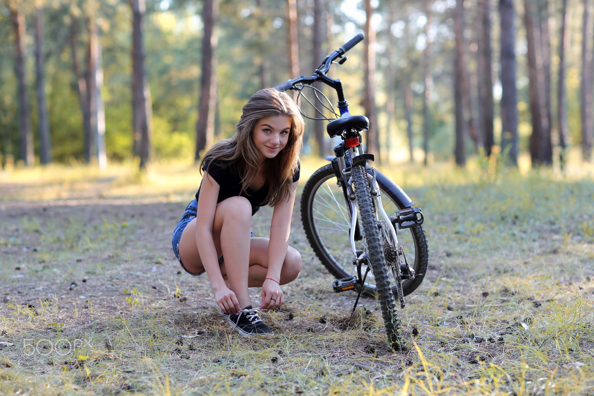 People 2048x1366 women trees forest smiling brunette jean shorts sneakers squatting women outdoors portrait Margarita Murat black top young women T-shirt women with bicycles legs vehicle outdoors bicycle blue shorts blue  jeans kneeling natural light